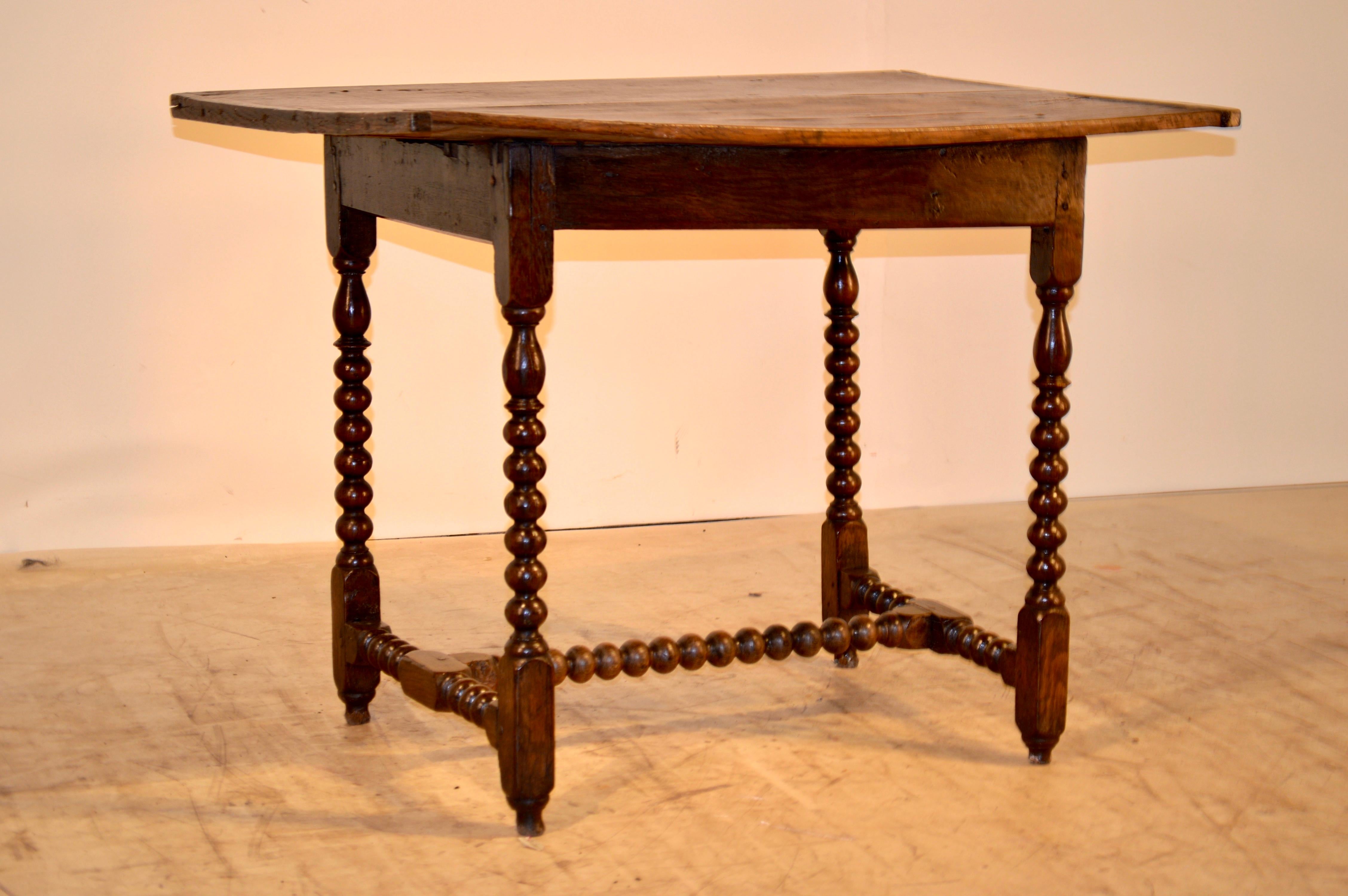 17th century English William and Mary oak side table with fabulous wear. The top is made up of two banded planks over a simple apron which is very Primitive. Supported on wonderfully hand-turned legs and stretcher. Losses to feet. Some wear,