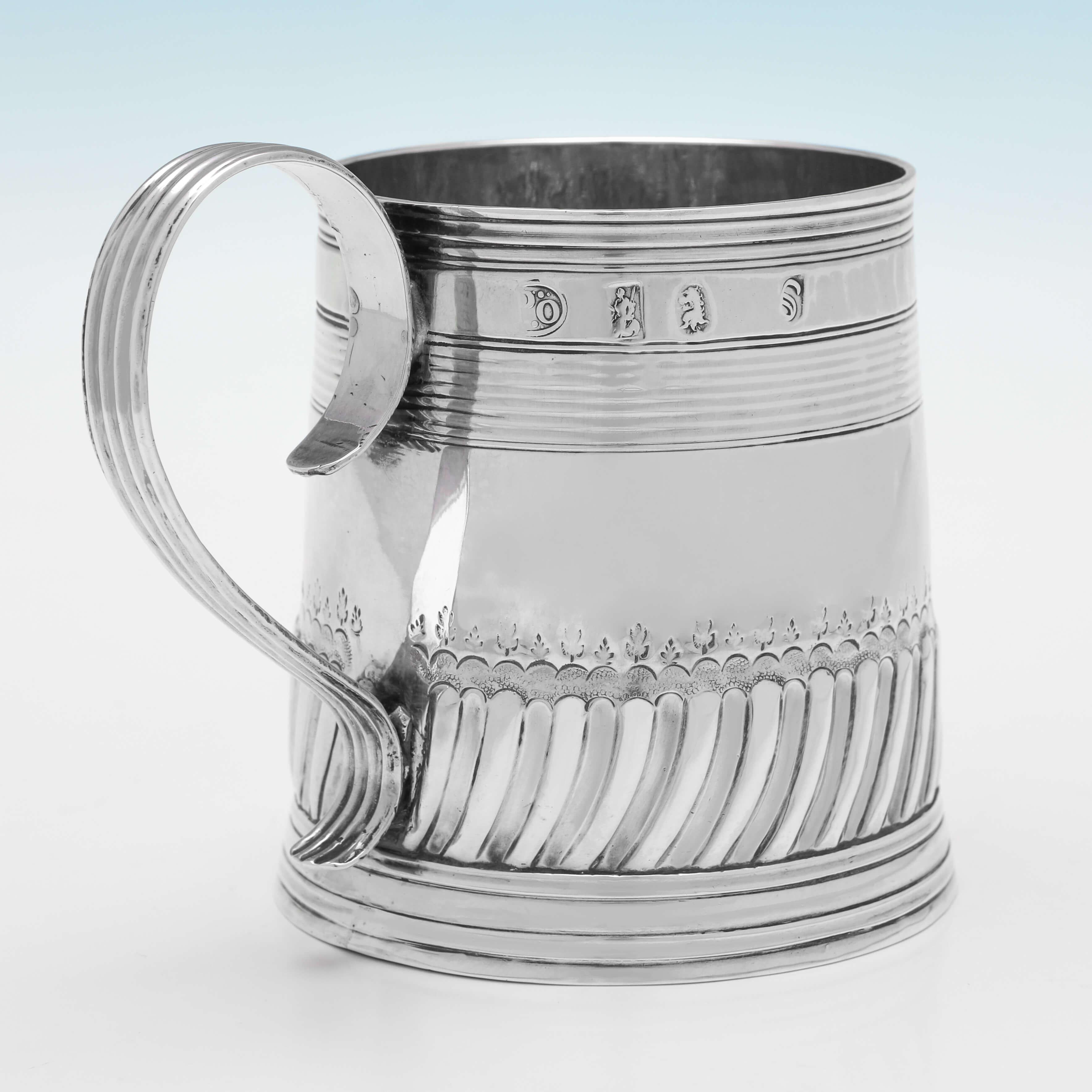 Hallmarked in London in 1699 by John Porter, this wonderful, William III Period, Antique, Britannia Standard Silver Mug, is straight sided, and features swirled fluting and bands of reed decoration to the body and a reed handle. 

The mug measures
