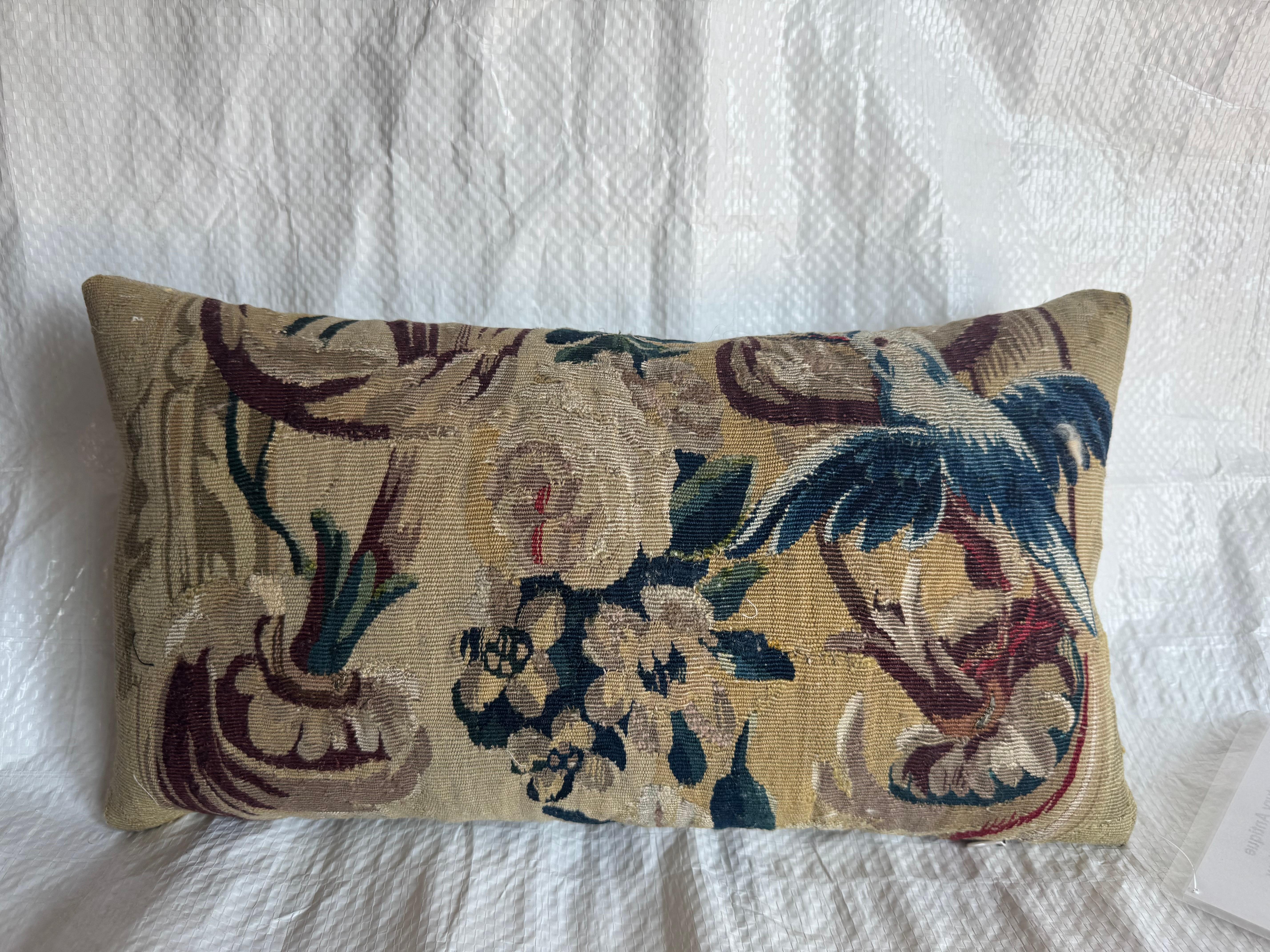 Dieses Kissen aus Brüsseler Gobelin aus dem 17. Jahrhundert zeigt einen anmutigen blauen Vogel inmitten von Akanthusblättern, zarten Blumen und Ranken - handgewebt aus Wolle mit Spuren von Seide. Die Farbpalette umfasst elegante Töne von tiefem