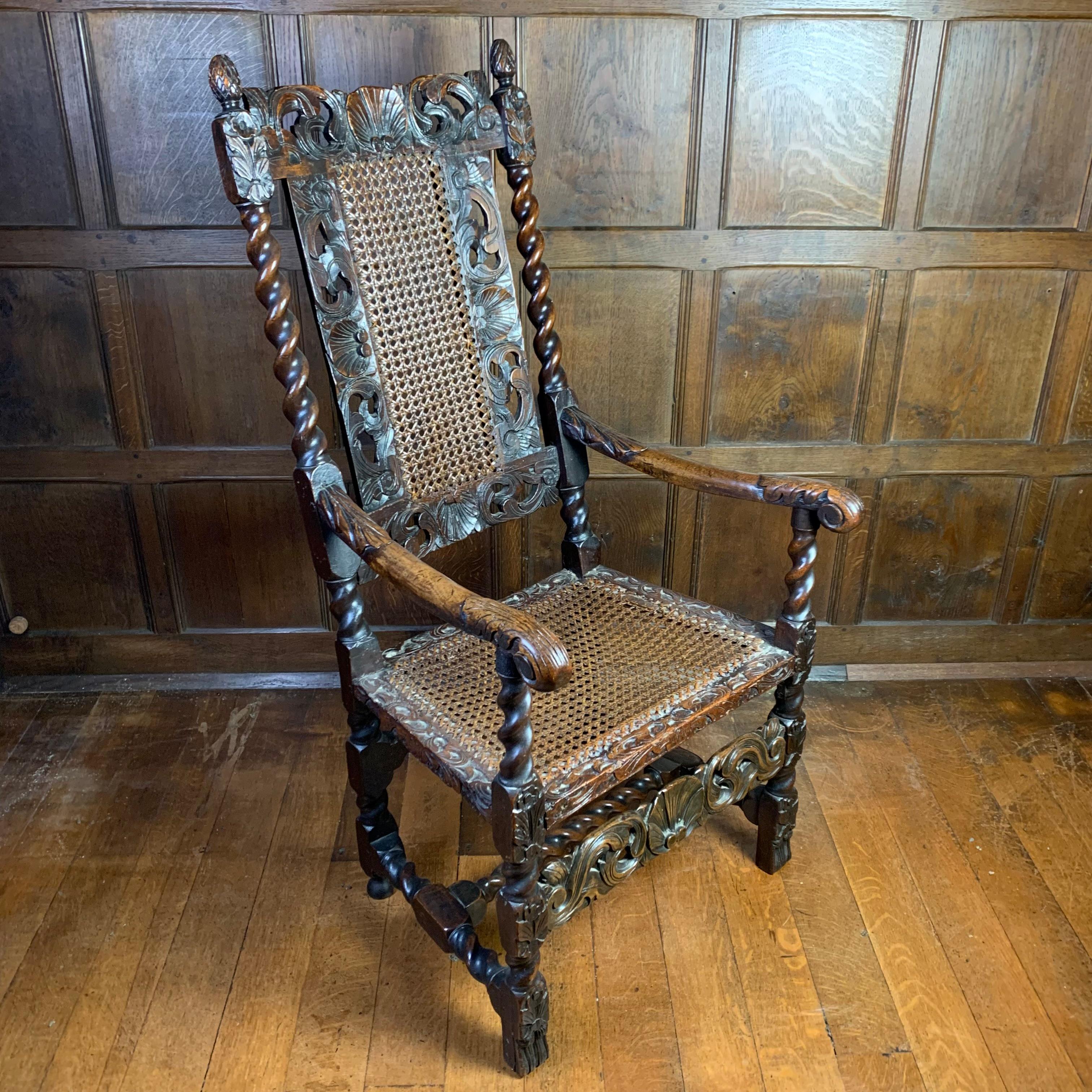 A well carved, high back, genuine 17th century Carolean walnut armchair, carved with flowerheads and foliate scrolls and a shell at the centre of the top rail, with caned back panels and seats. The chair dates to about 1680 and is in sound condition