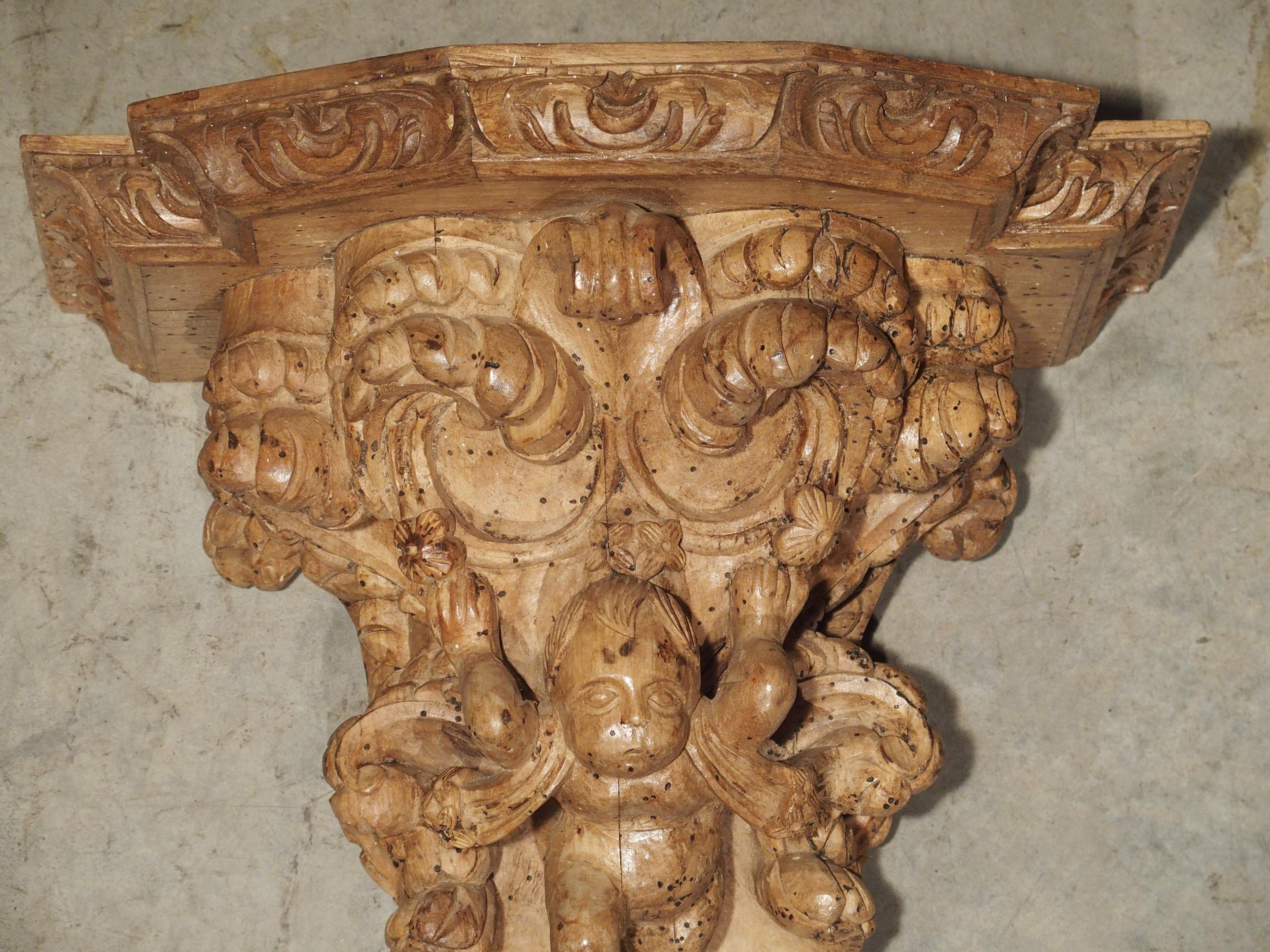 From Italy, this beautiful hand carved, natural wood wall bracket dates to the 1600s. The entire bracket is flush with robust C-scroll carvings, acanthus leaves and feathered ornamentation. The top has a center molding that is horizontal with canted