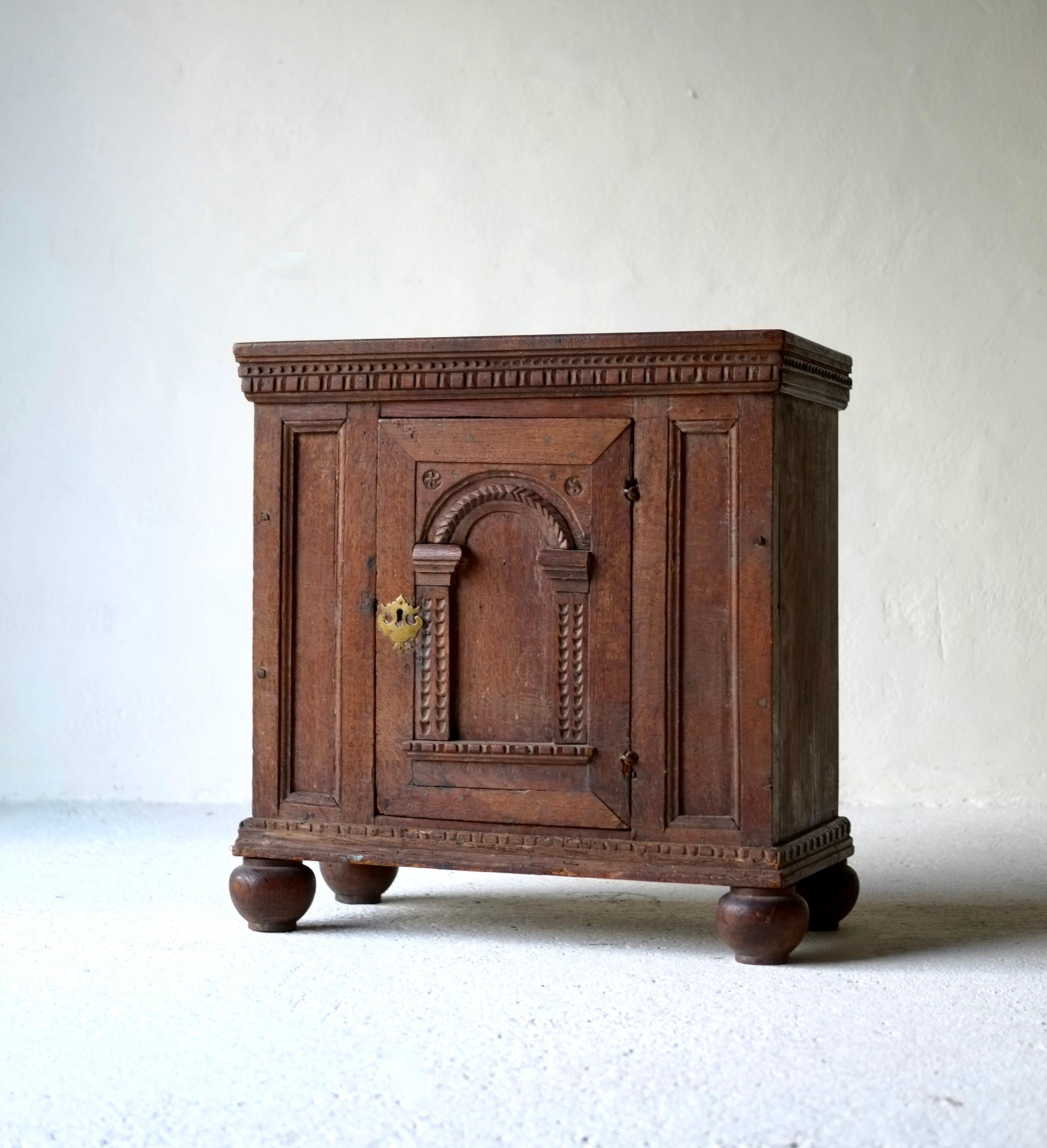 Armoire en chêne français du début du 17e siècle. 

Il présente des détails sculptés complexes.

En bon état. Les pieds semblent avoir été ajoutés plus tard. 

H 74 L 71 P 38 cm