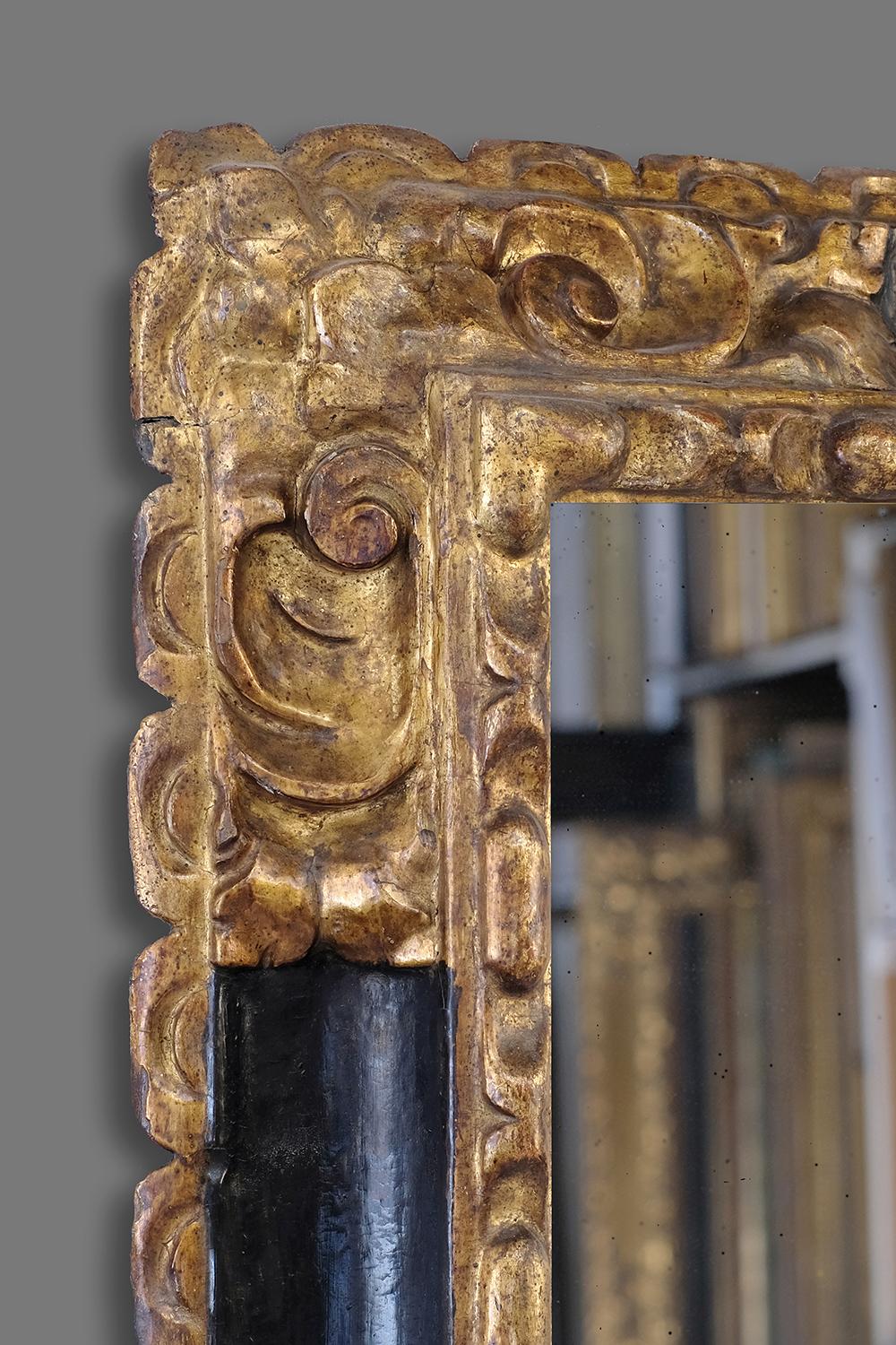 A unique and splendid mid-17th century hand carved Spanish Baroque frame. It has a bolection profile with a carved cabochon sight; corner-&-center stylized cartouches and scallloped back. The frame retains its well preserved original parcel