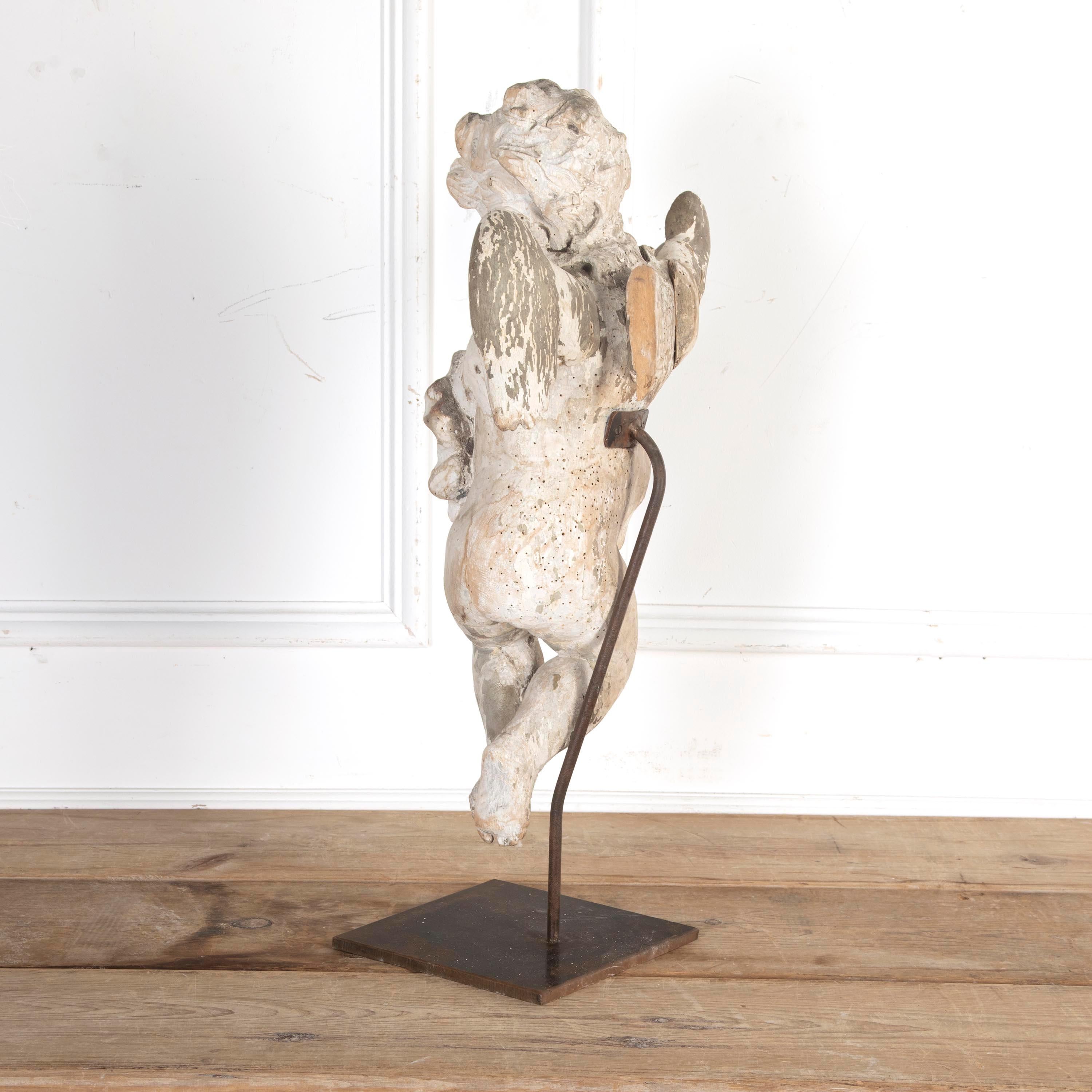 Large 17th century carved wooden cherub mounted on a metal stand.

These 'putti' were a prominent part of religious and mythological iconography in Renaissance and Baroque Italy.

Featuring the remains of paint to the curled hair and fabric