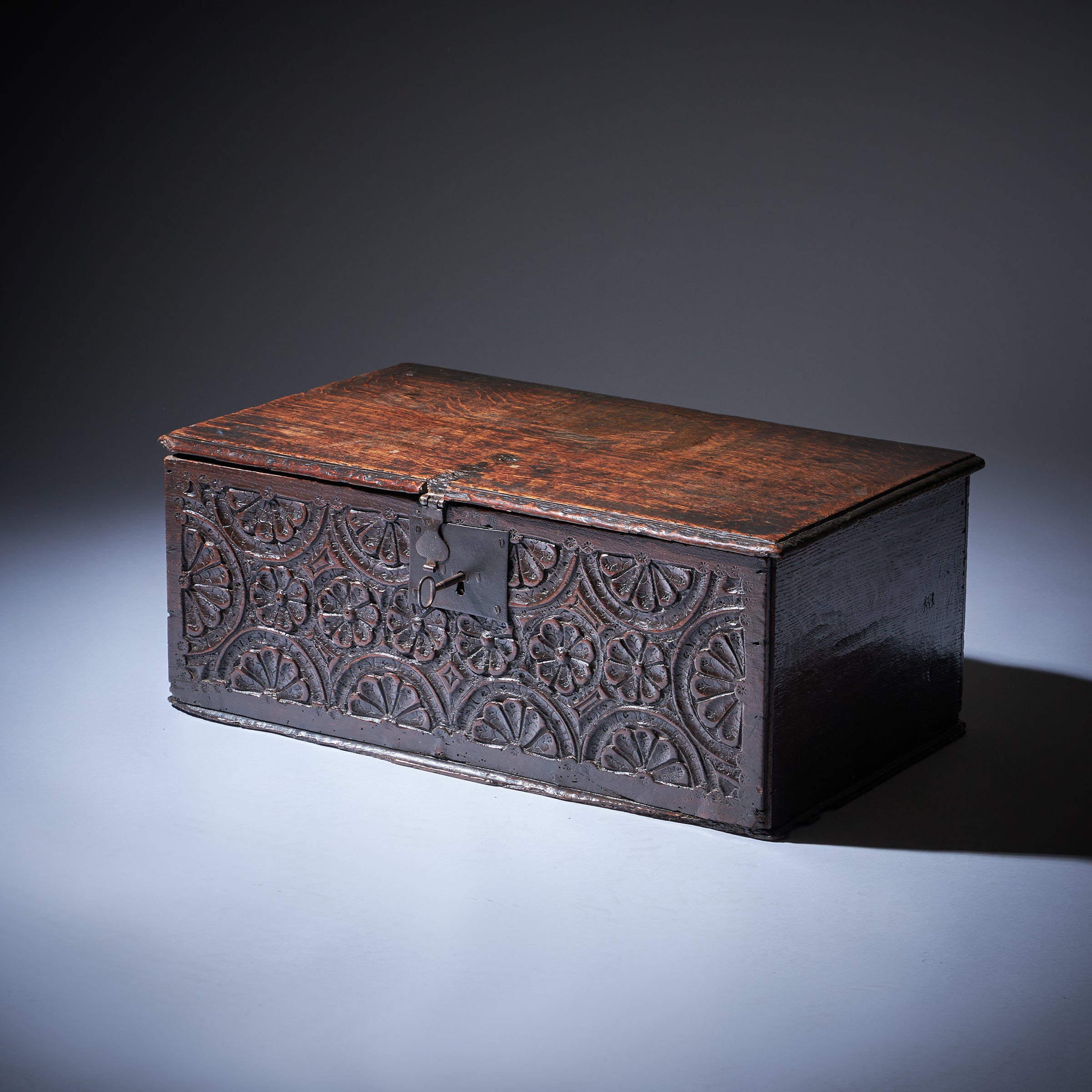 An attractive early 17th-century carved oak box of boarded construction from the reign of Charles I, circa 1640. England

The box is deeply carved and punch decorated to the frieze in a geometric pattern with rose (guilloche) and lunar decoration,