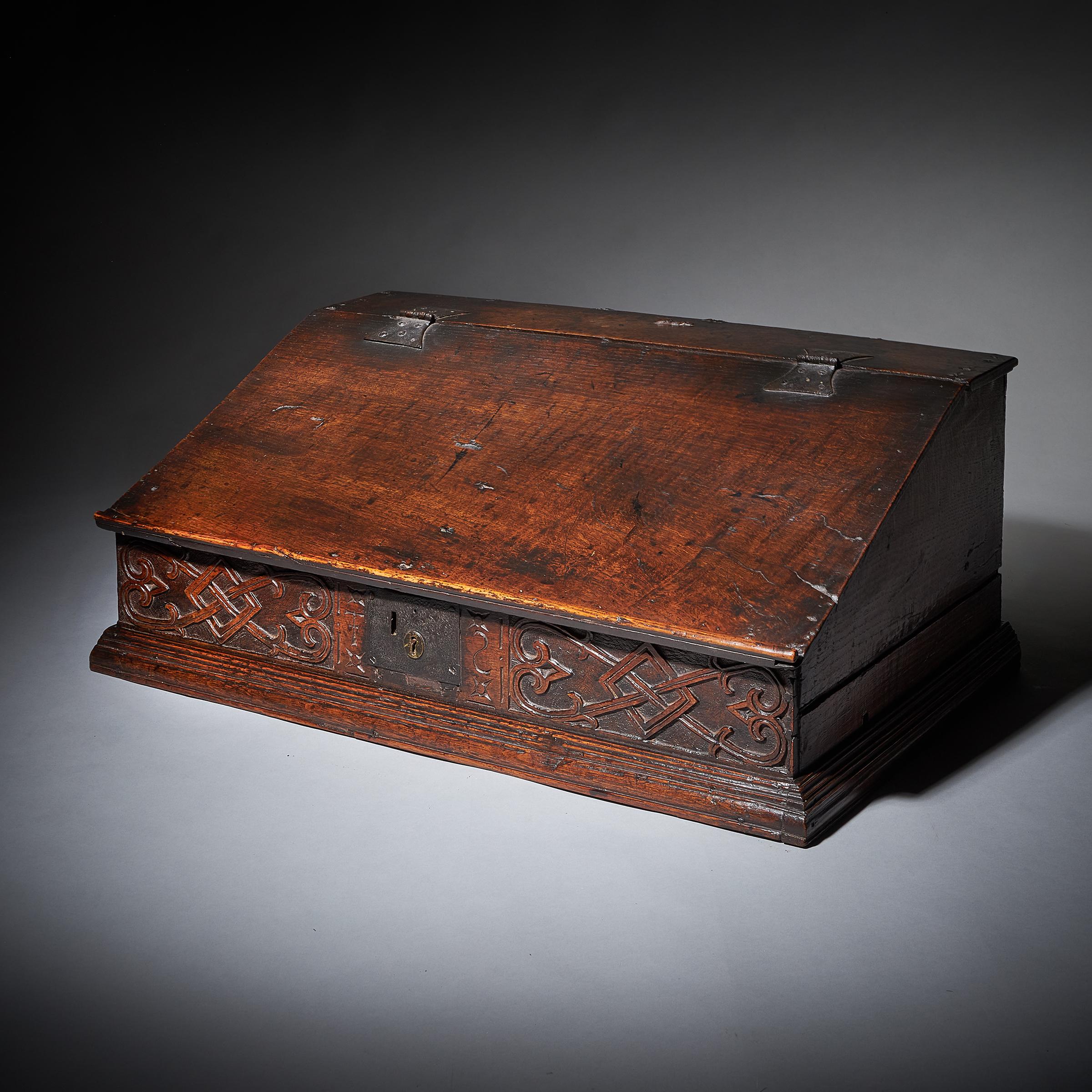 A rare 17th-century Charles II carved oak writing or desk box, circa 1660. England.

The box opens on the original butterfly hinges to reveal a fitted interior of three oak-lined drawers. 

The deep carving to the frieze is very much in the