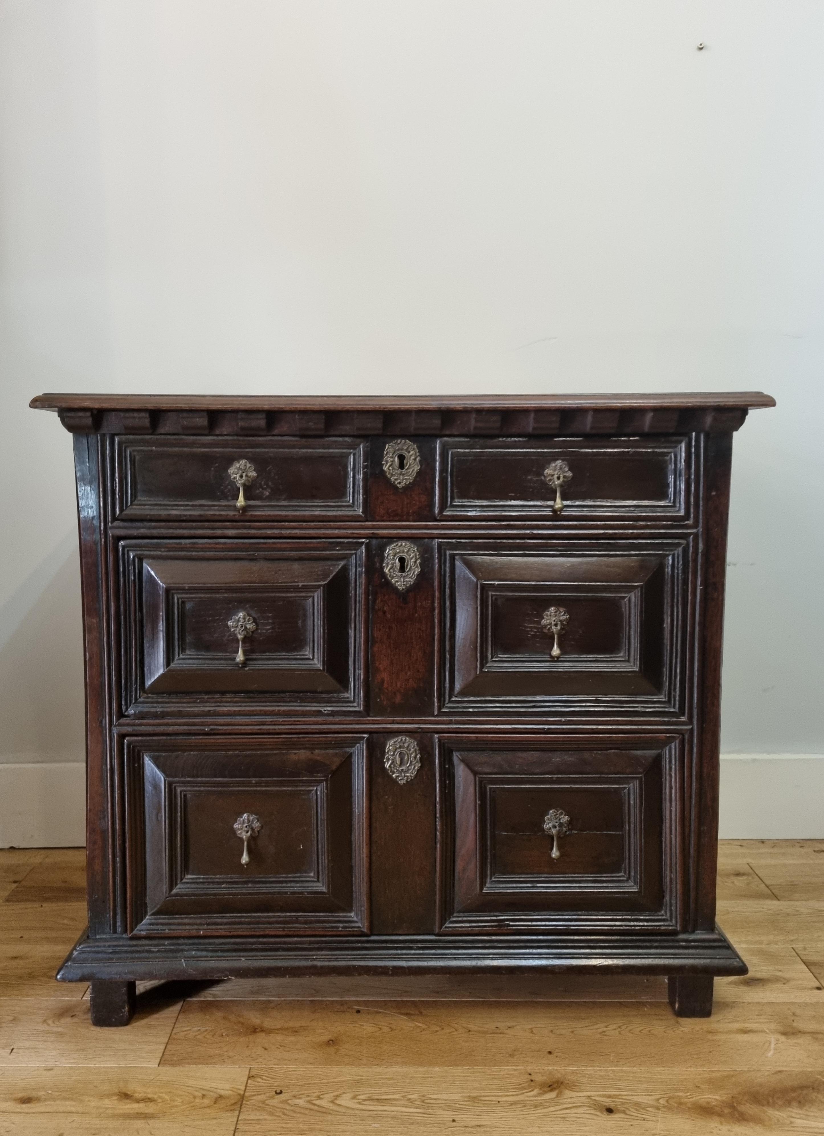 A fine 17th-century Charles II nicely proportioned oak chest of drawers. It features a rectangular planked top. The chest has 2 short and two long drawers, lined with oak, brass drop handles, and escutcheons. It stands on its original stile feet. 