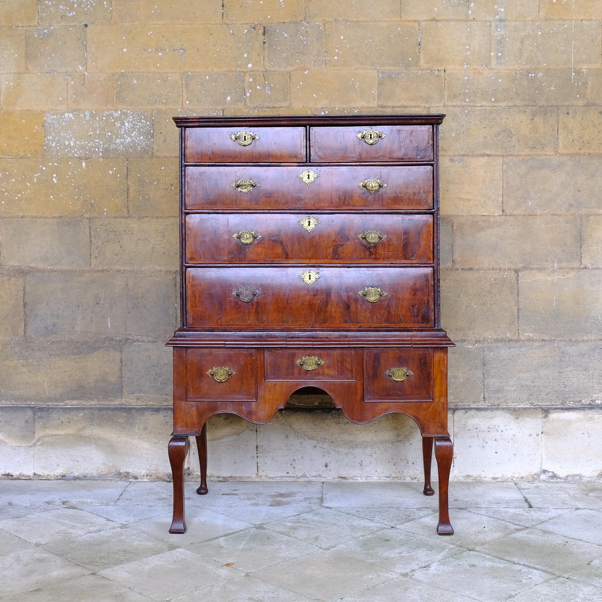 An early 17th century chest of drawers, in the Queen Anne style, on a later, most likely George I stand. With beautiful walnut veneers and mouldings. The chest comprising two short over three long drawers, the base with a central drawer flanked by a