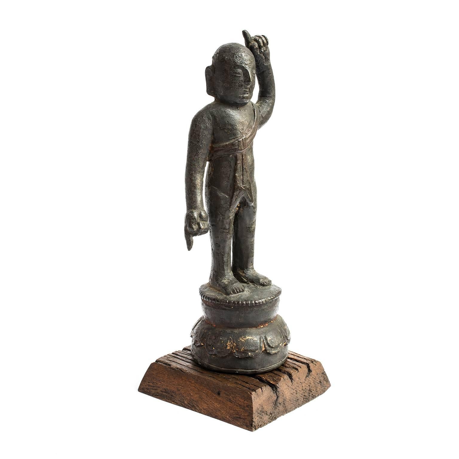 Fine cast bronze figures created over 400 years ago during China's Ming dynasty are rare and highly appreciated. In this exceptional example, a spirited young boy stands on a lotus blossom with a sash draped across his chest. Traditionally, this