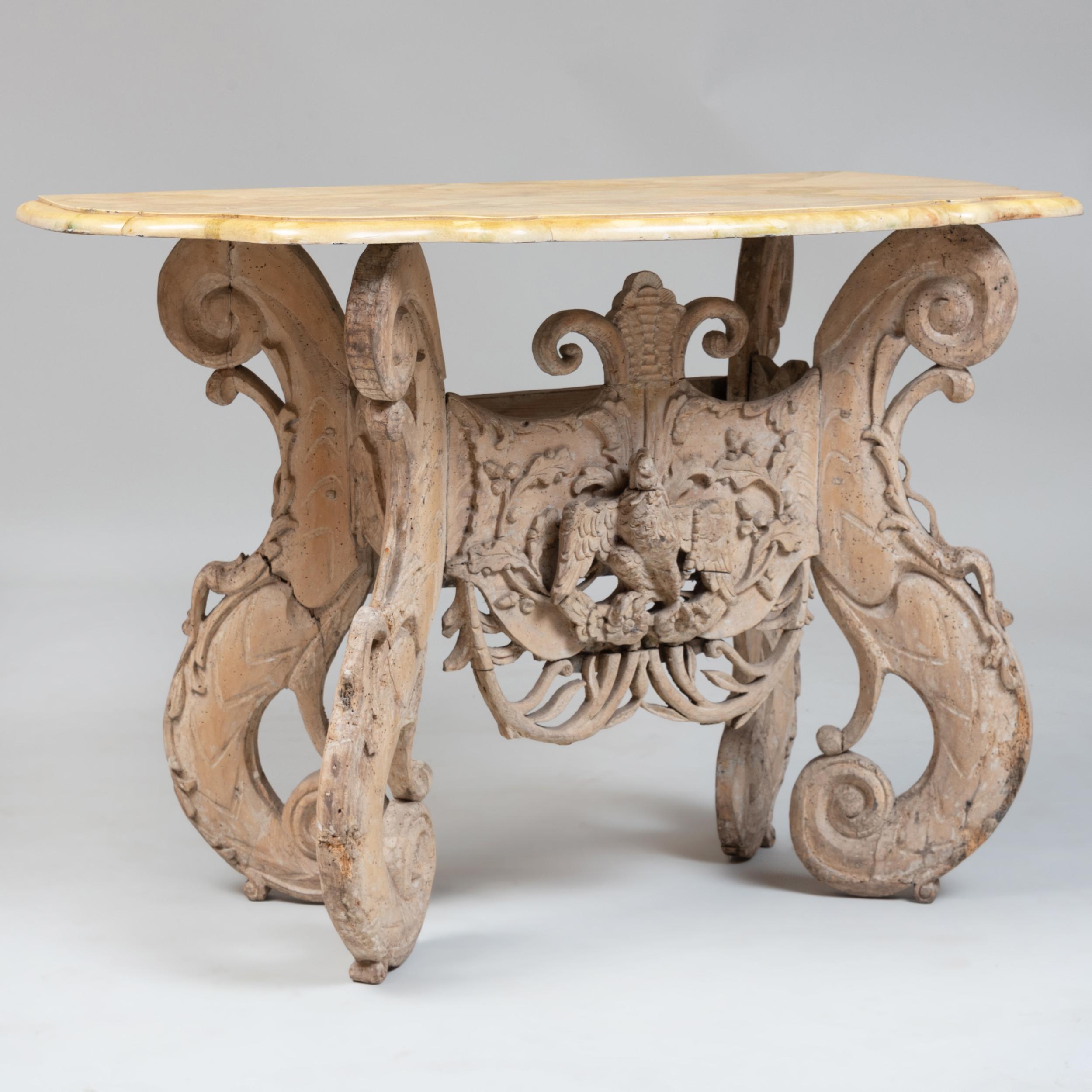 Period Charles II washed beechwood table of the mid-17th century. Rare. Four school legs, carved foliate and central eagle cartouche. Oak leaf and acorn central motif. Later shaped faux marble top and included a chic faux red porphyry top

Ex