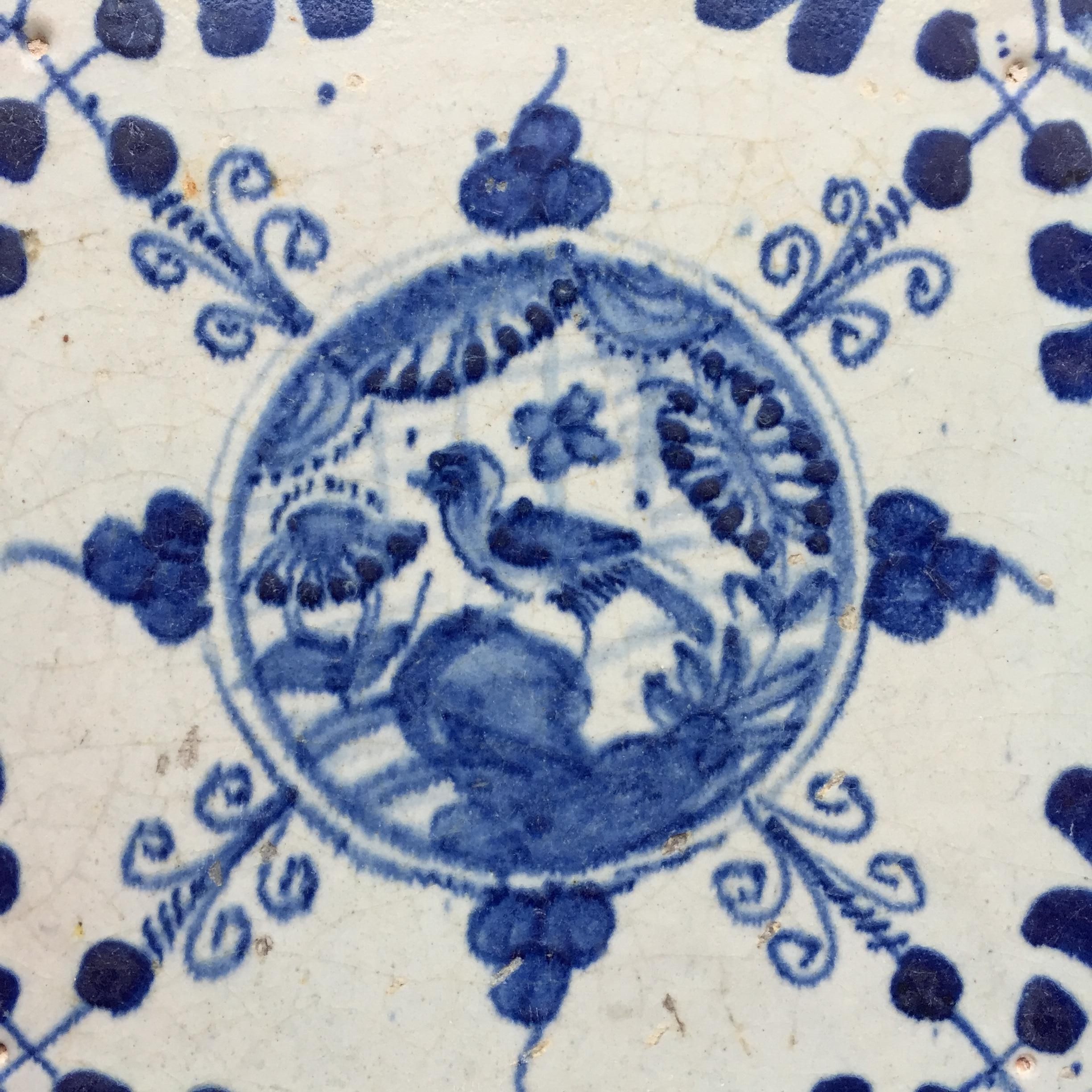 The Netherlands
Circa 1620 – 1640

A blue and white Dutch tile with a decoration of a Chinese garden with a bird on a rock. Influenced by the Chinese porcelain from the Wanli Period.
Painted in a circle with leaves and curls around the circle. In