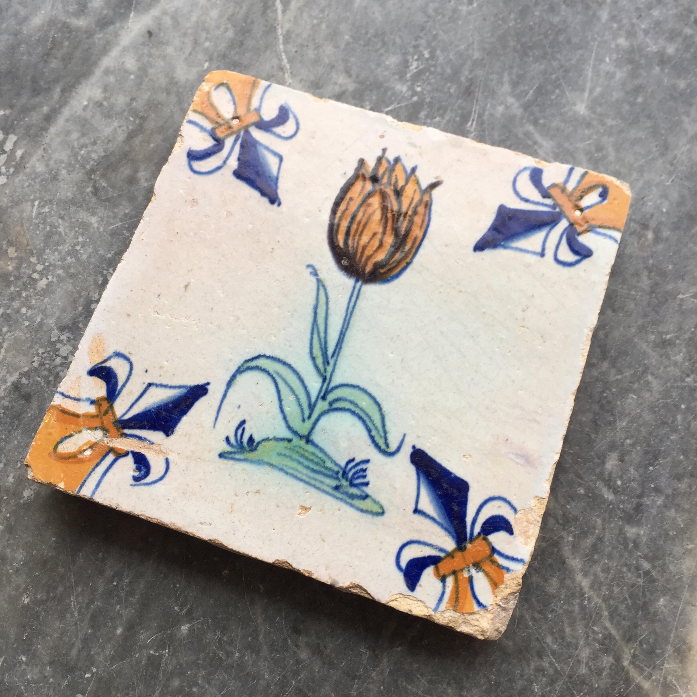 Fired 17th Century Dutch Delft Tile with decoration of a flamed orange tulip For Sale