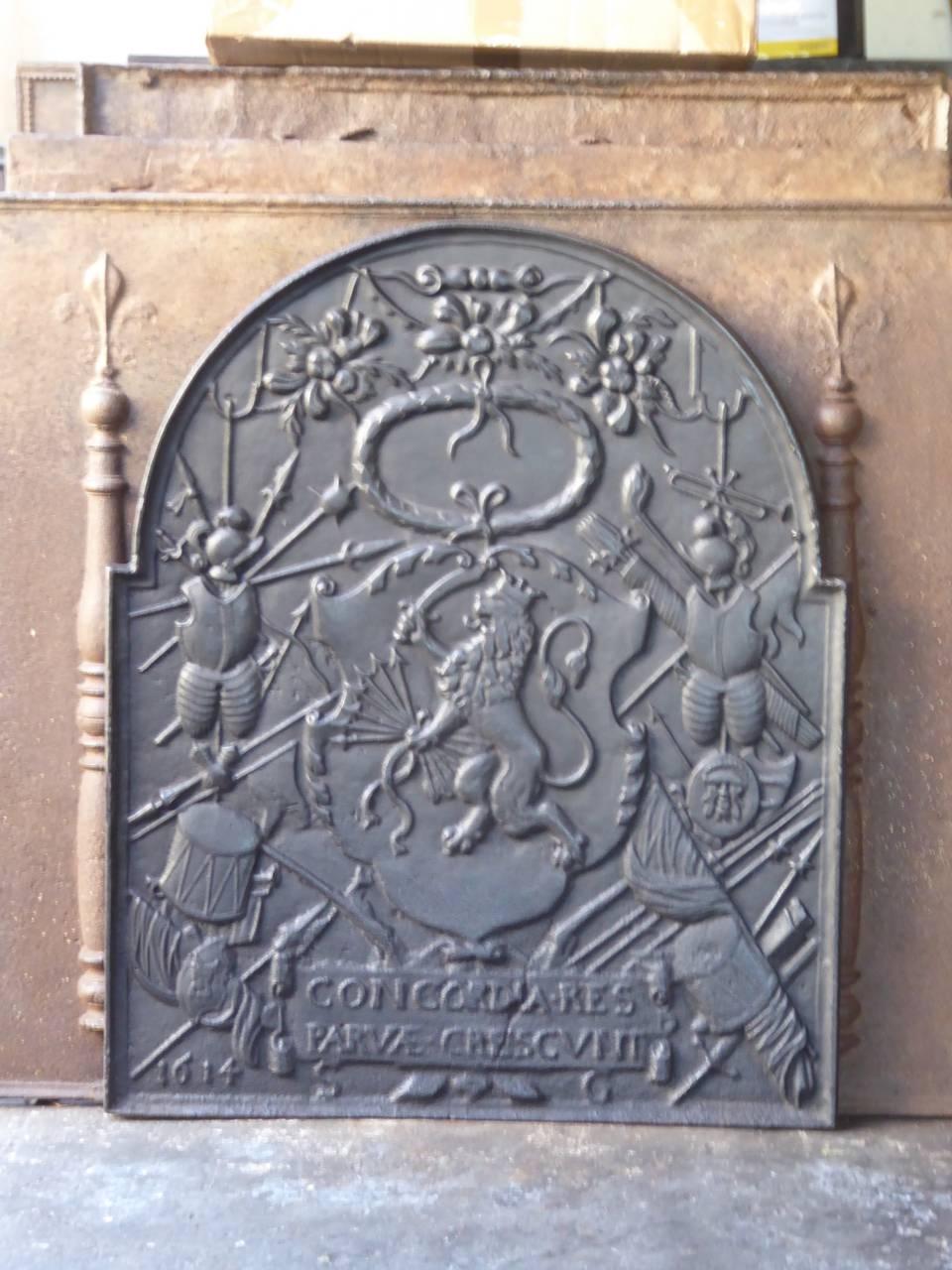 17th century Dutch Louis XIV fireback with a coat of arms. The fireback is made of cast iron. It depicts the Dutch lion with seven spears, symbolizing the seven provinces of the Dutch Republic in the 17th century. The text 'Concordia res parvae