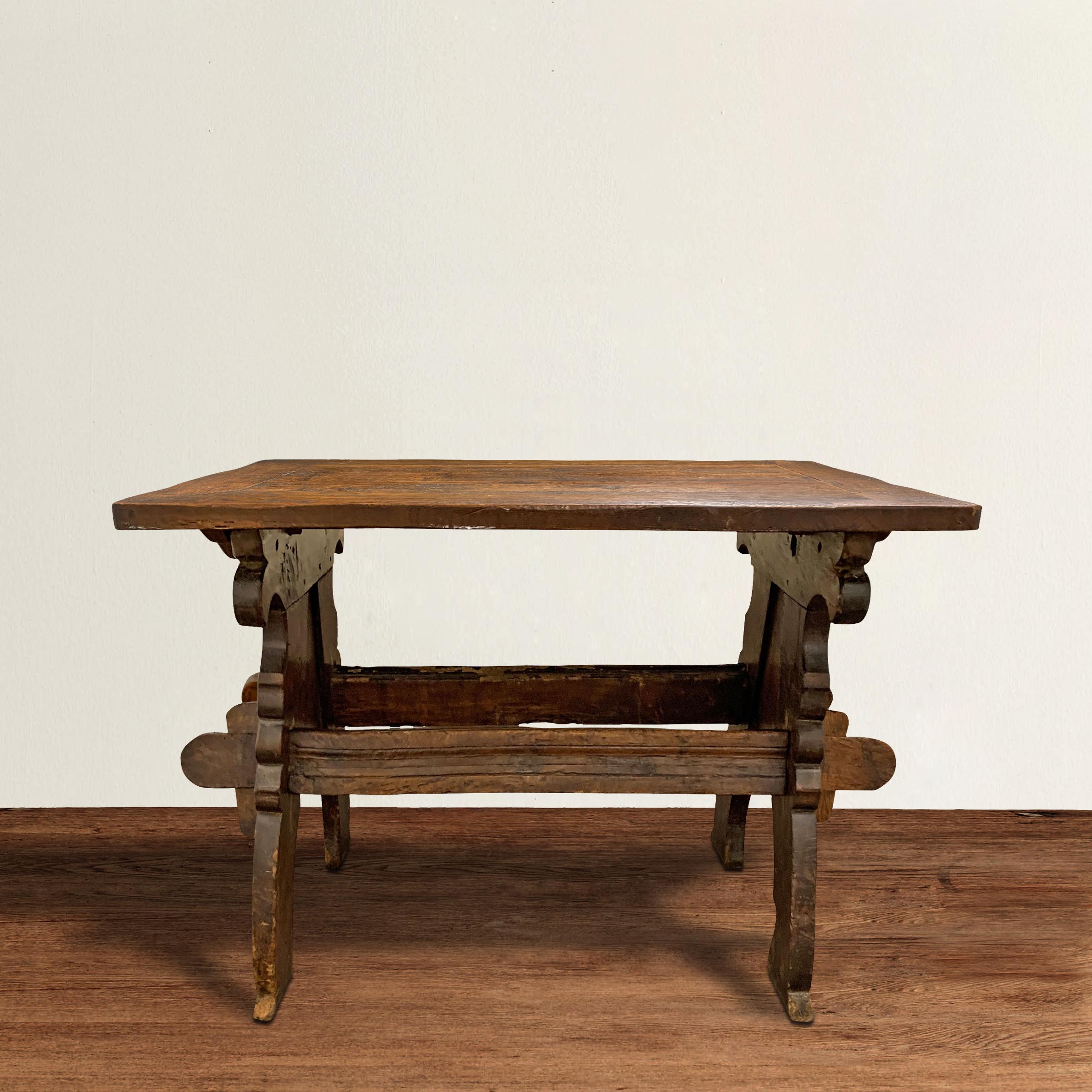 A fantastic and remarkable 17th century Dutch double-sided oak trestle table with beautifully carved ends with curved legs, and stylized floral carved spandrels. The top is well-worn with a patina that only four hundred years of use can bestow.