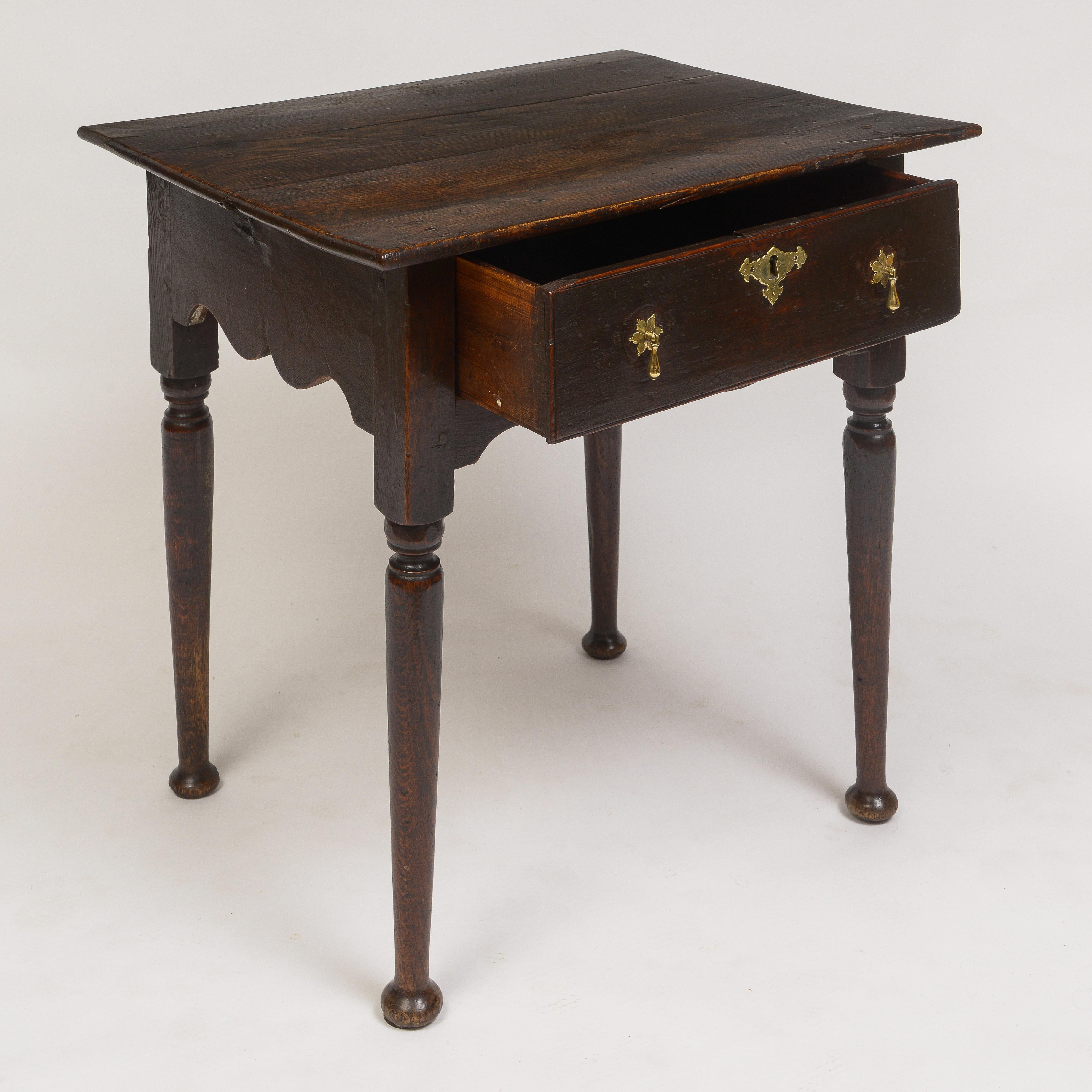 Over sized top over a single drawer with period brass hardware.
Carved plinth supported by turned legs ending in a pad foot.
