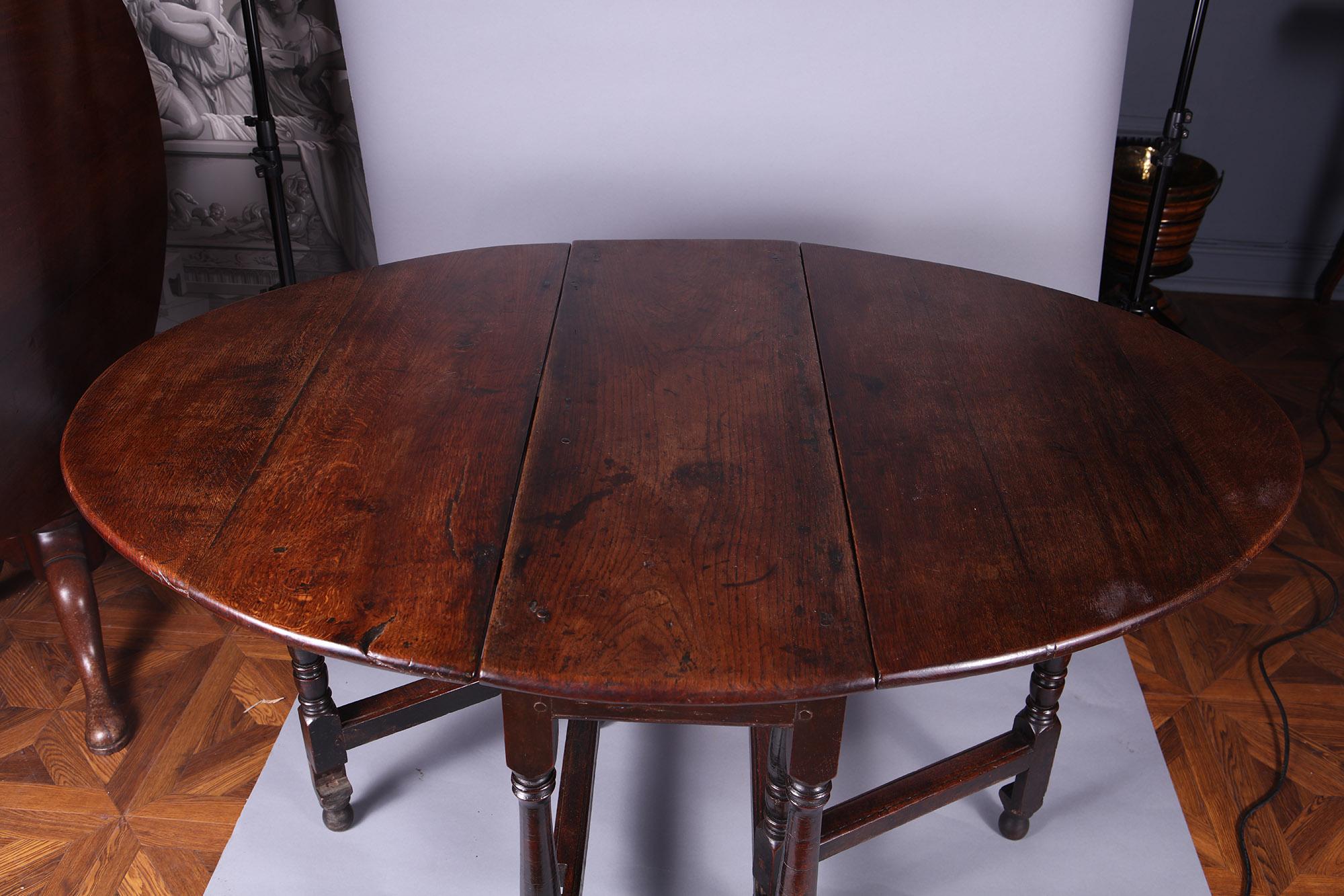 Eichenholztisch mit Fallblättern aus dem 17. Jahrhundert, mit einer zentralen Platte aus Ulme und Fallblättern aus Eiche, die auf gedrechselten Beinen mit Streckern stehen.