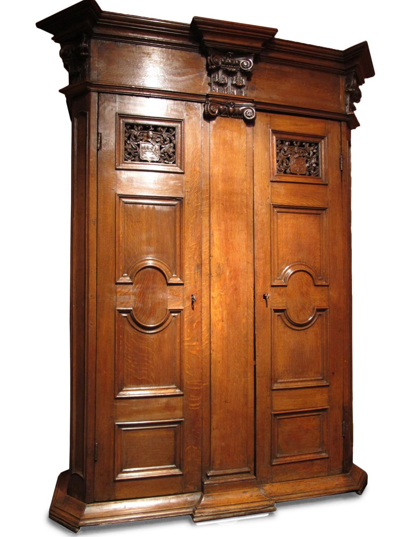 This interesting oak cabinet of germanic workmanship is a wedding furniture.

The cabinet rests on a molded base, opens with two doors located on each side of a large pilaster.
The frame, surmounted by an ionic capital is decorated with a flower