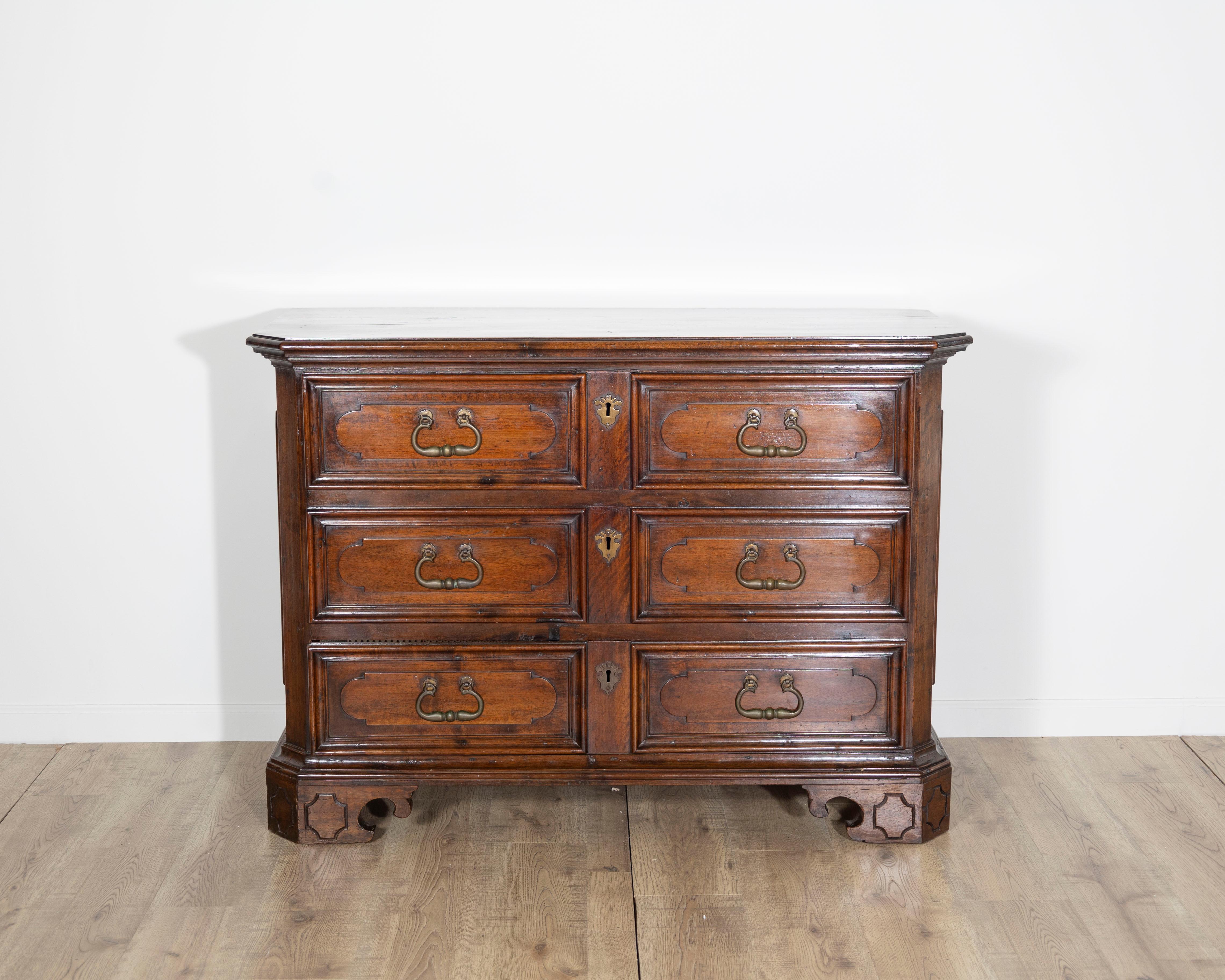 Une élégante commode Eleg du XVIIe siècle, fabriquée de main de maître en noyer massif au cours de la seconde moitié des années 1600. Cette pièce italienne raffinée met en valeur l'art exceptionnel de l'ébénisterie baroque, avec une silhouette forte
