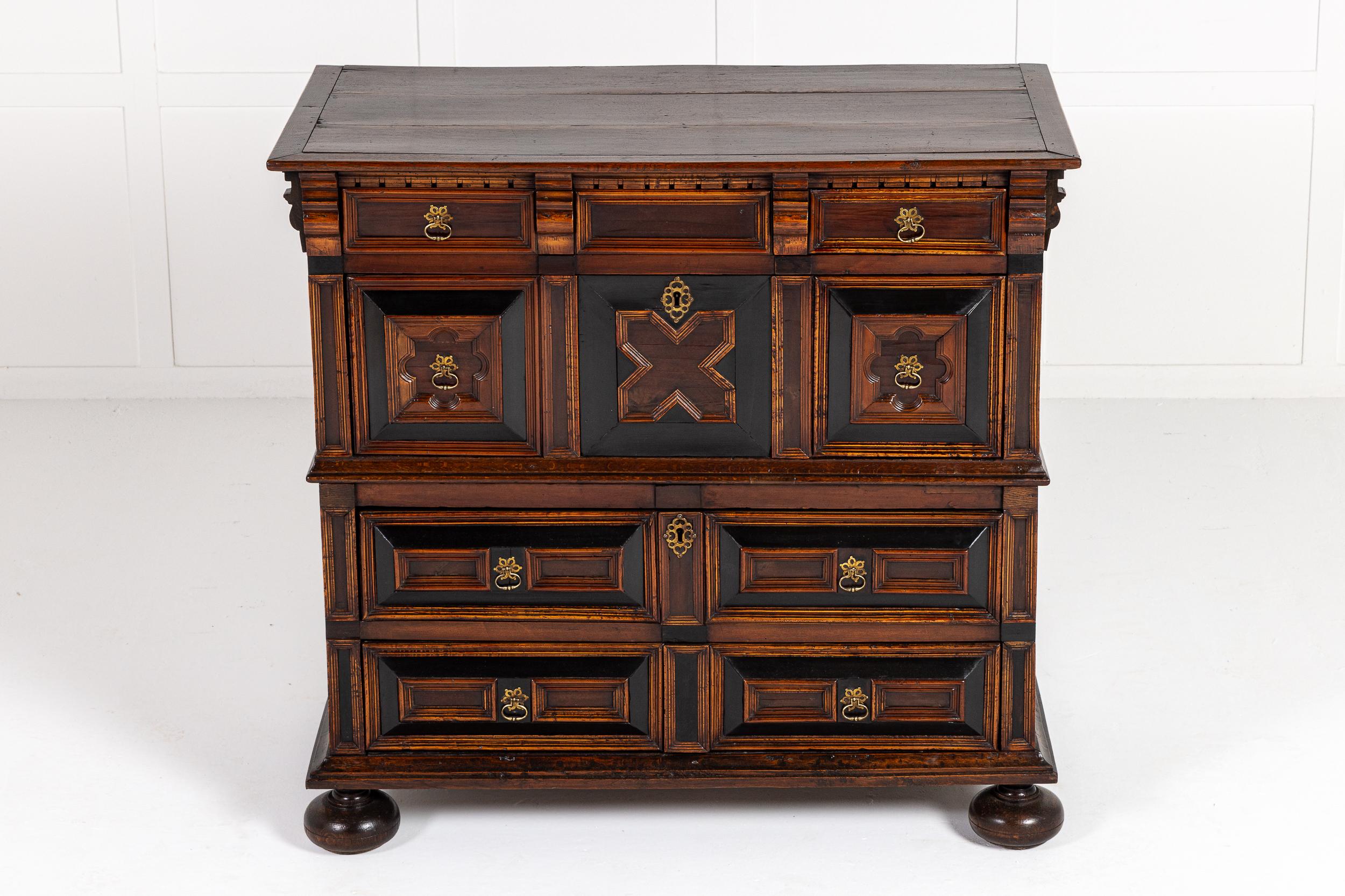 Eccellente cassettiera inglese del XVII secolo in Oak, noce e ebanizzato in due sezioni.

Una bella cassettiera realizzata in quercia e noce con ulteriori dettagli ebanizzati. Il piano è a fasce incrociate e a listelli, il fregio a dentelli e