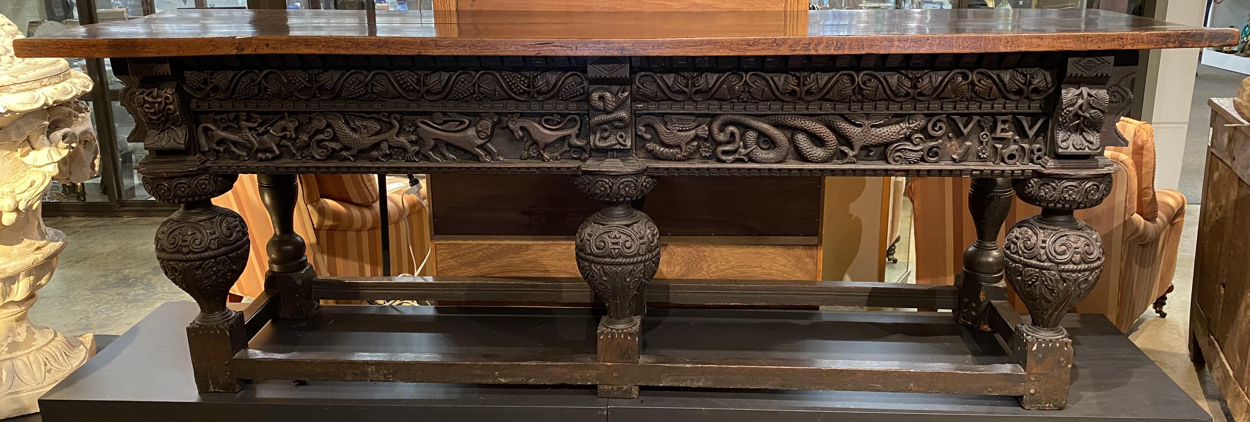 A finely detailed 17th century oak rectangular sideboard or serving table with heavily carved frieze decoration, including carved dragons, griffins, and serpents, other mythical creatures, and flowers, along with the initials GVEV and dated 1618,