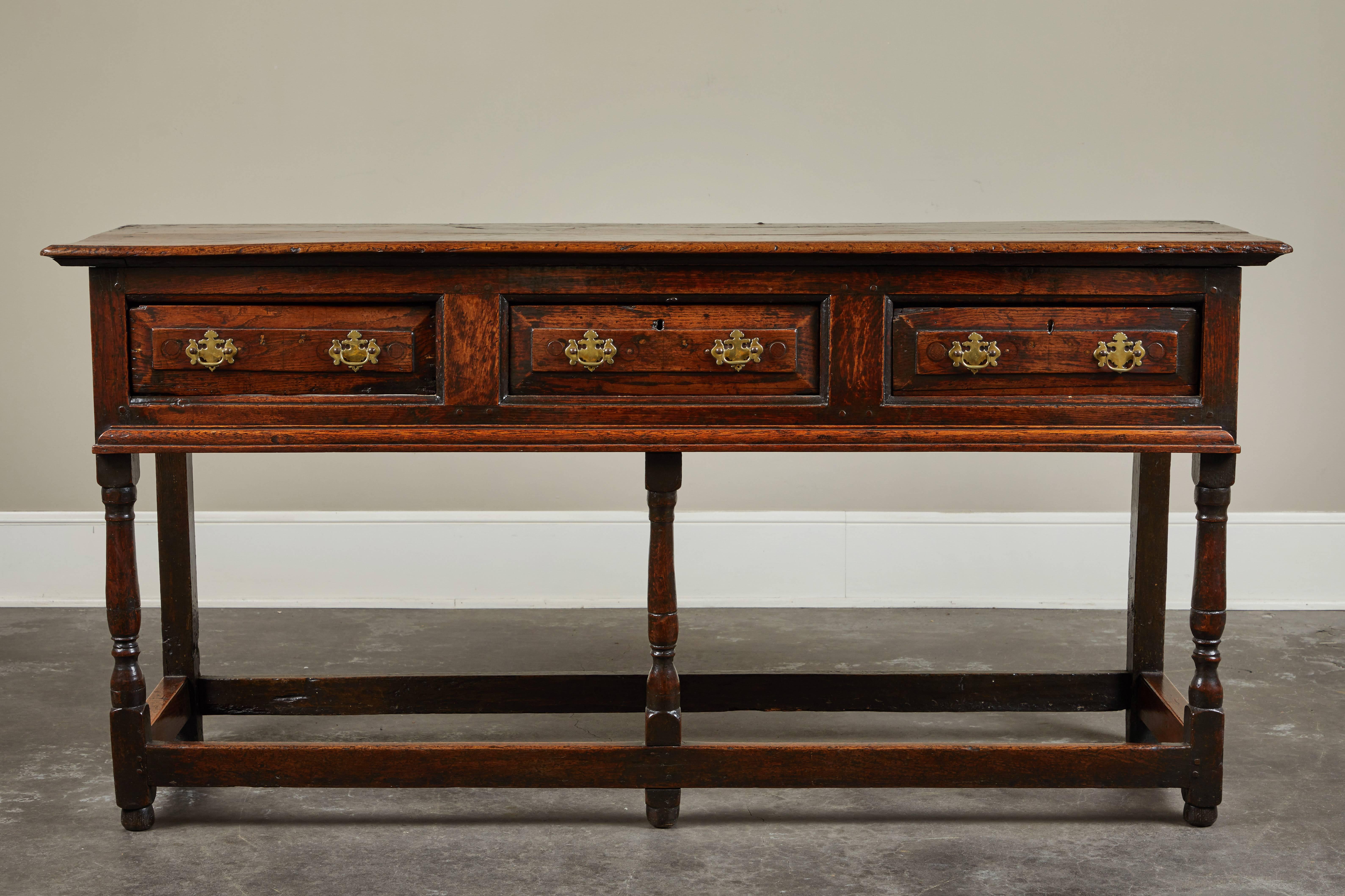 English oak Jacobean stretcher base sideboard with fielding to the drawers and molded drawer surrounds, circa 1650.