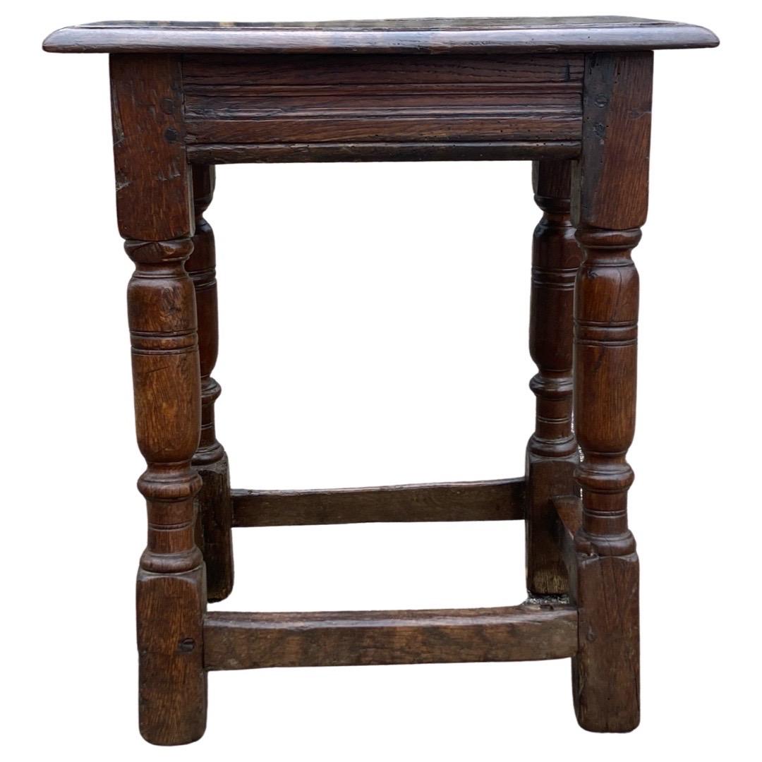 Joint stool made in England in the late 1600s using oak. This is a beautiful, and old, small stool that shows great proportions and can still be used on a daily basis. The top consists of a single board with ogee edge, that has been repaired with an