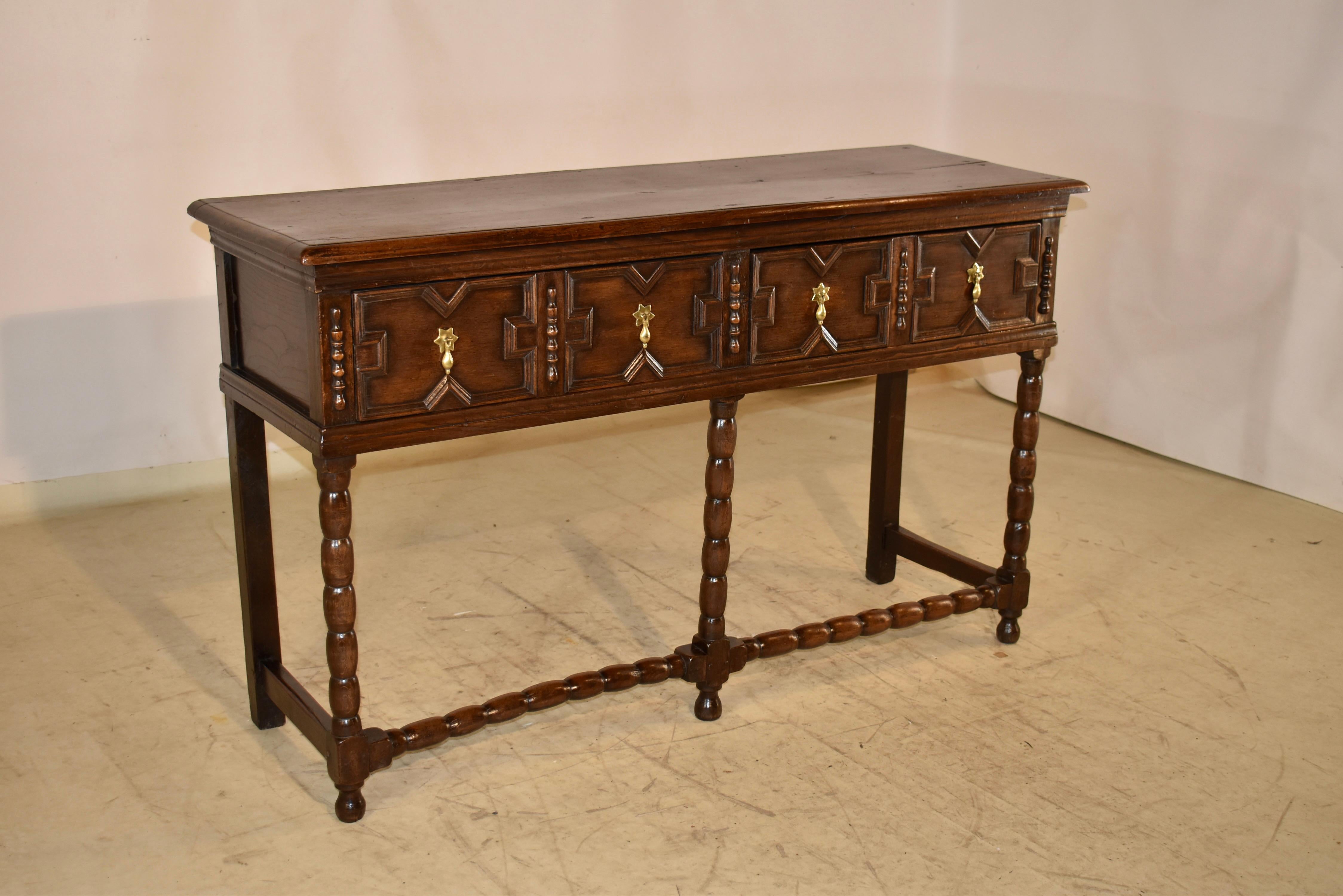 Credenza d'epoca in quercia del XVII secolo proveniente dall'Inghilterra.  Il piano è ricavato da un'unica tavola e presenta un bordo smussato, che scende verso i lati a pannelli e due cassetti nella parte anteriore con decorazioni geometriche a