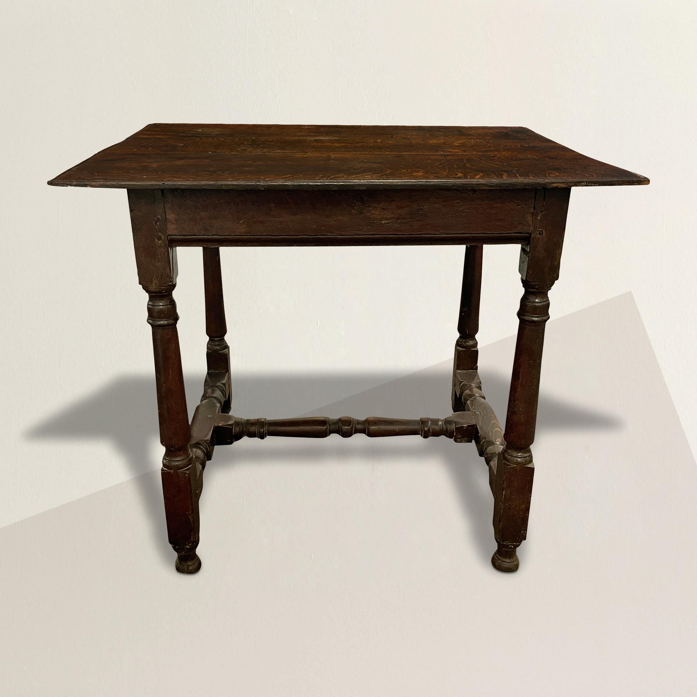 A remarkable 17th century English William and Mary oak table with a three-plank top over a plain frieze, and with tapered turned legs, turned stretchers with a well worn surface, and raised on turned feet. The perfect side or end table next to your