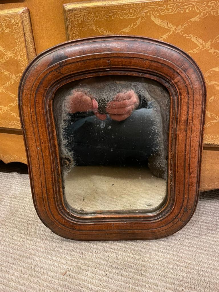 Sweet little carved walnut 17th century English Jacobean period mirror frame with the original glass. This simple small frame exudes character, with the unusual rounded corners and lovely molding. Best is the rich honey patina that only comes from