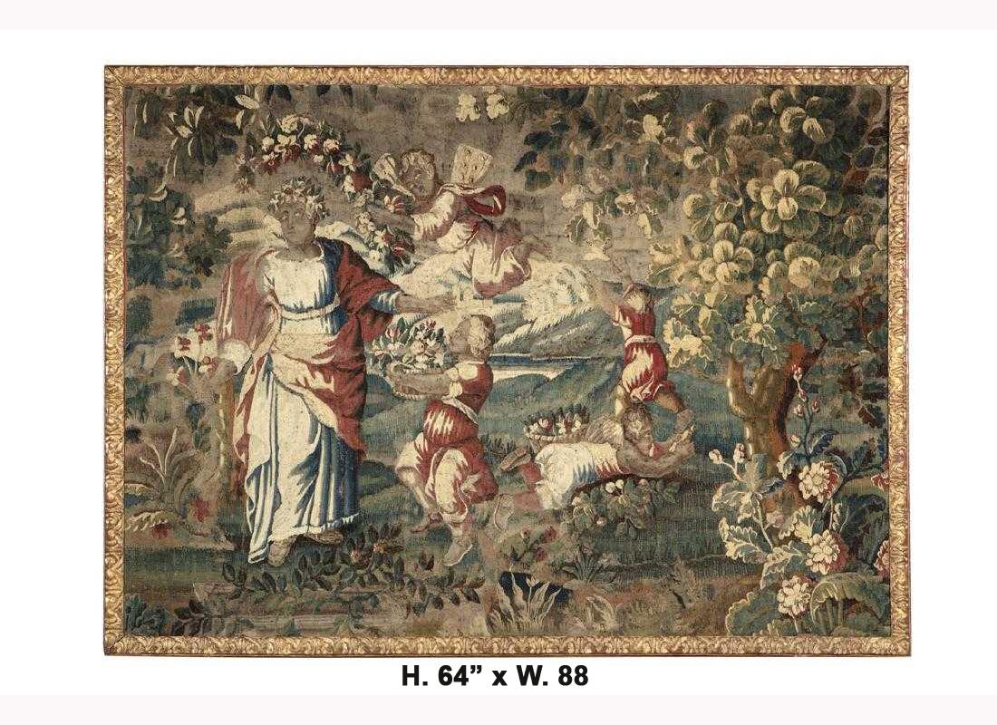 17th century Flemish Baroque framed handwoven tapestry.
Depicting a mythological scene of a noble in traditional garments accompanied by a figure holding a fruit and flower basket and a flying cupid in a lush garden, all within a carved giltwood