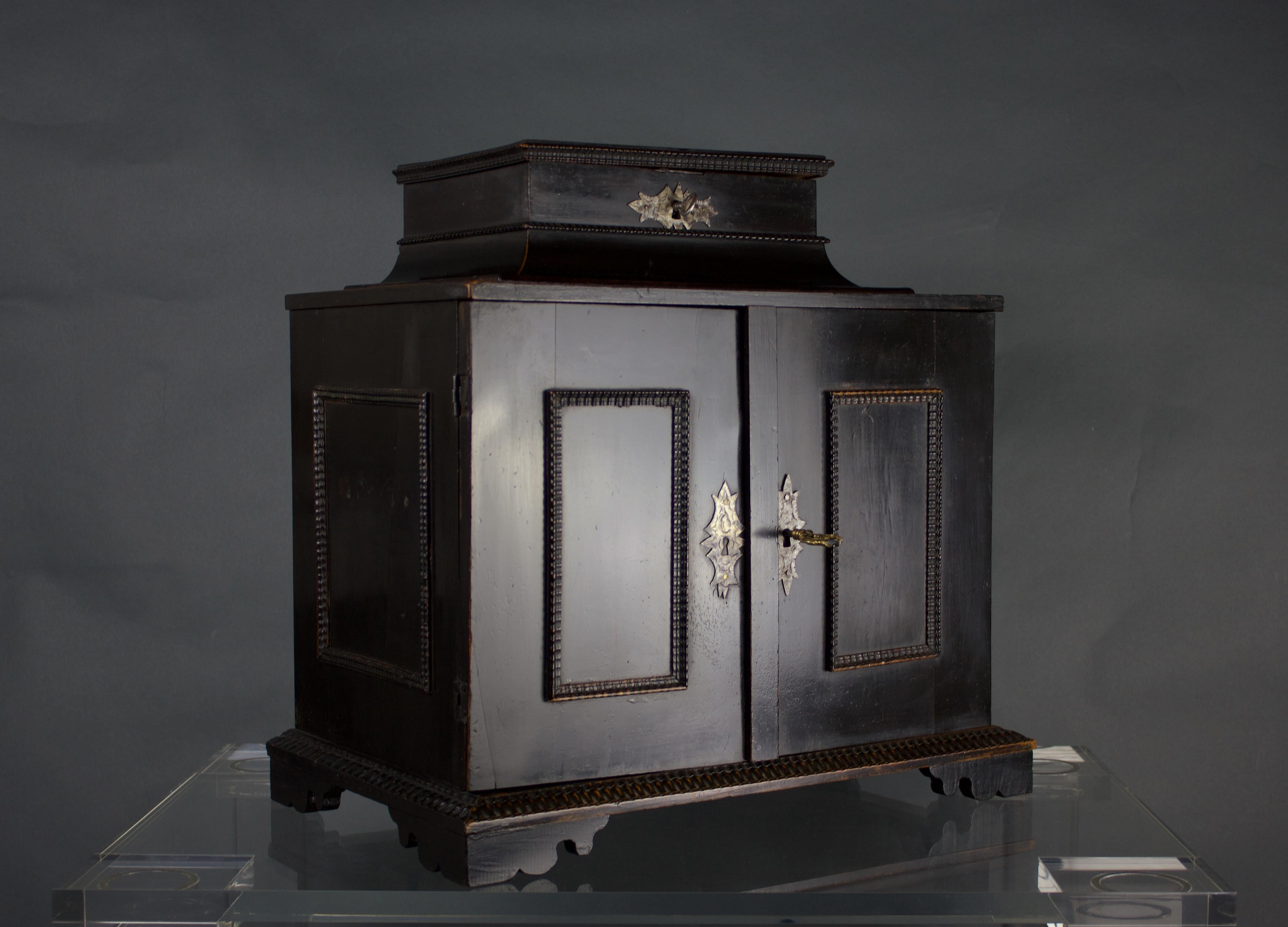 A fine 17th Century Flemish Ebonised Pearwood Table Cabinet, Circa 1650. This cabinet is a testament to the ingenuity and artistry of Flemish craftsmen from the 17th century. The ebonised pearwood exterior boasts a dark, luxurious sheen, while
