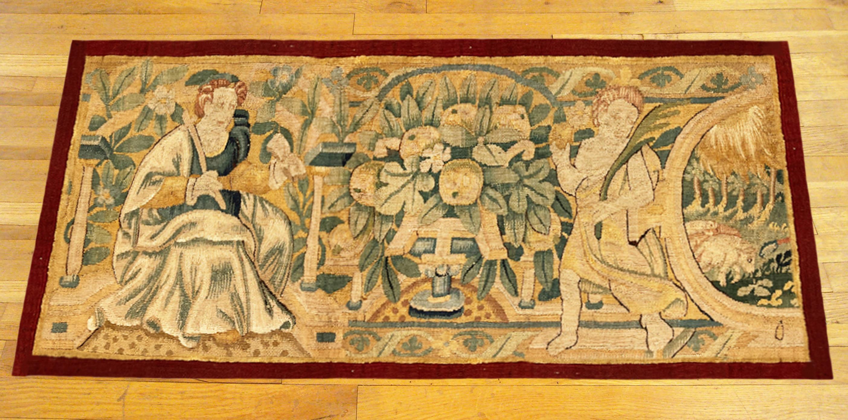 A 17th century flemish historical tapestry panel. This horizontally oriented decorative tapestry panel depicts a regal female figure at left, with a floral reserve at center, and with a mythological angelic figure at right. The central area is