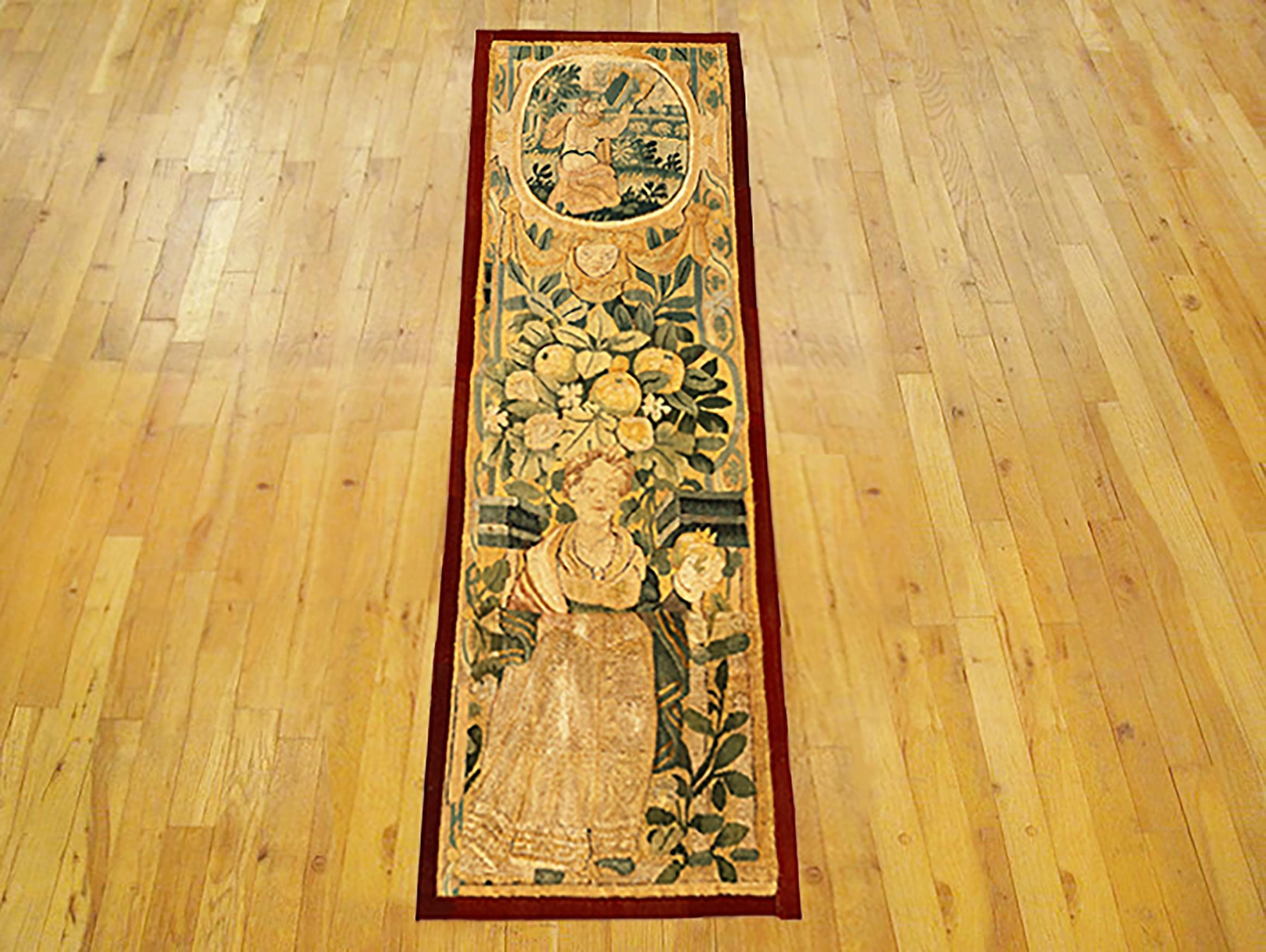 A 17th century Flemish Historical Tapestry panel. This vertically oriented decorative tapestry panel depicts a female figure at bottom, with a floral reserve above her, and with another female figure in a pendant cartouche at top. The central area