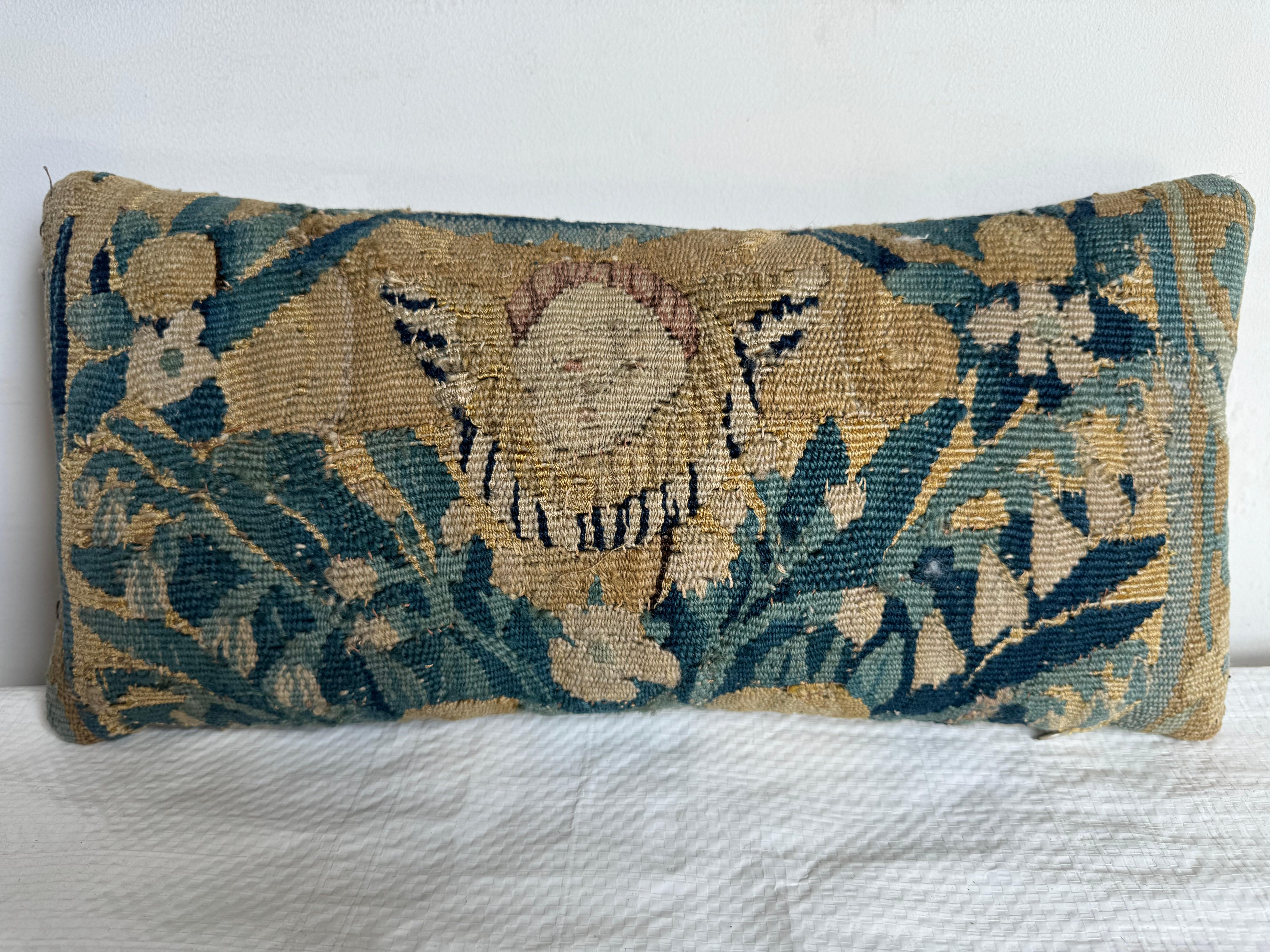 Oreiller flamand du XVIIe siècle, 16 x 7 pouces - une pièce rare et magnifiquement travaillée qui met en valeur les travaux d'aiguille complexes et les motifs vibrants caractéristiques des tapisseries flamandes du XVIIe siècle. Cet élégant oreiller