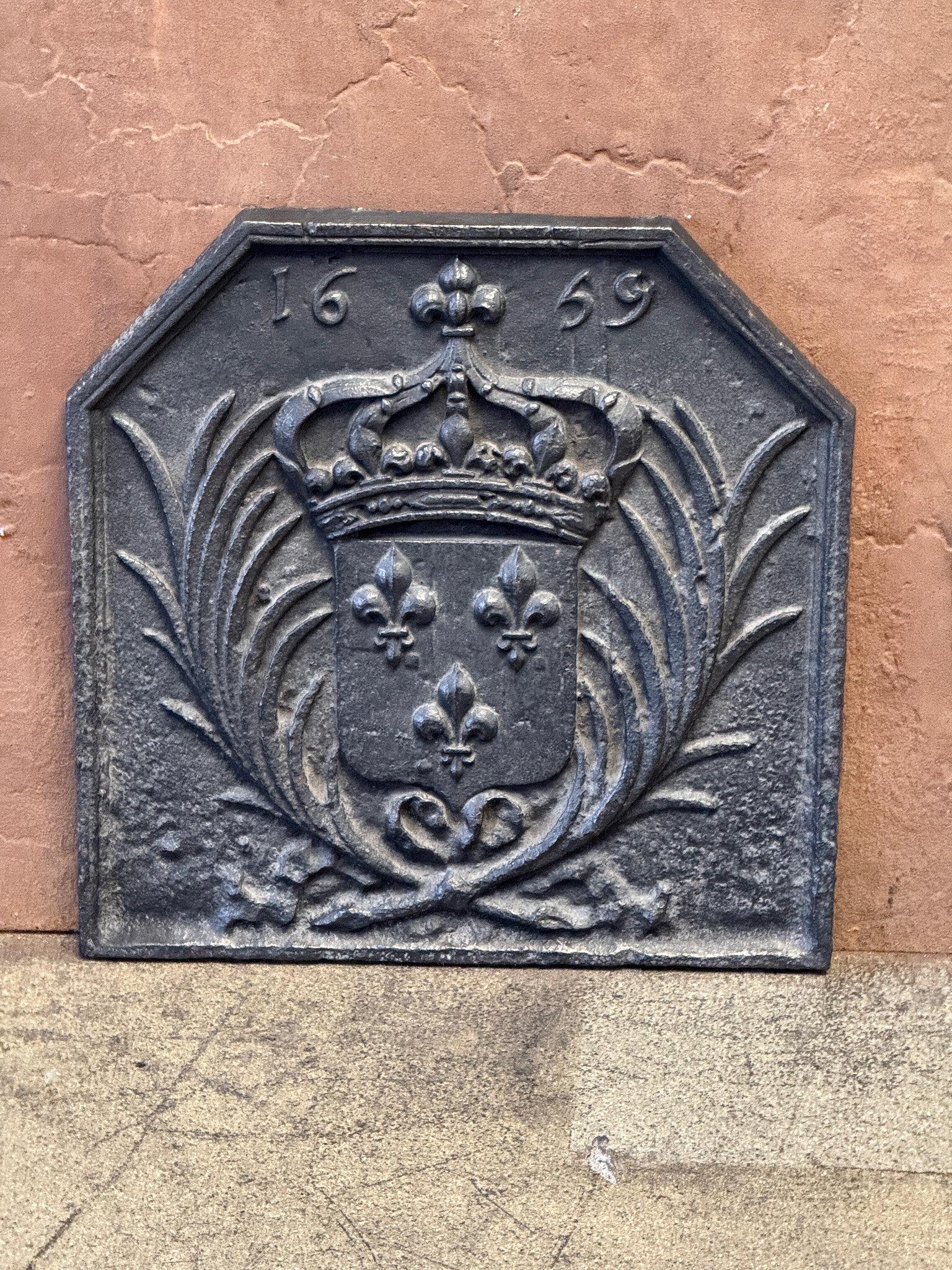 Caminetto francese del XVII secolo con le armi della Francia. La corona simboleggia la regalità e la foglia di palma la vittoria. Periodo Luigi XIV.

La patina del focolare è di colore nero / peltro.
