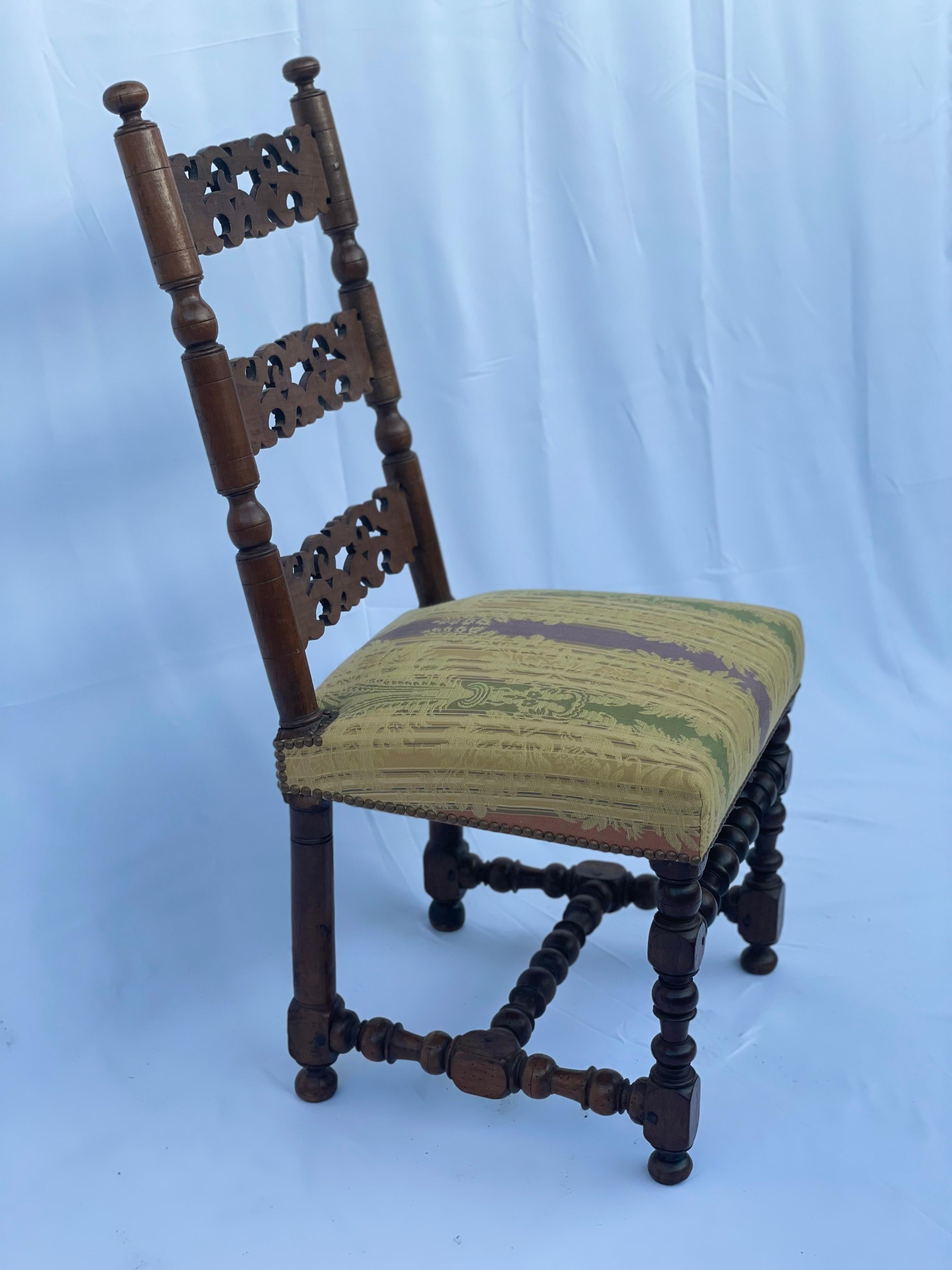 Beautiful French walnut chair from the 17th century, with twisted legs and cushioned seats. The chairback is nicely done and openly worked in three parts. The cushioned seats are in mustard tones and rich in details, the pattern represents acanthus