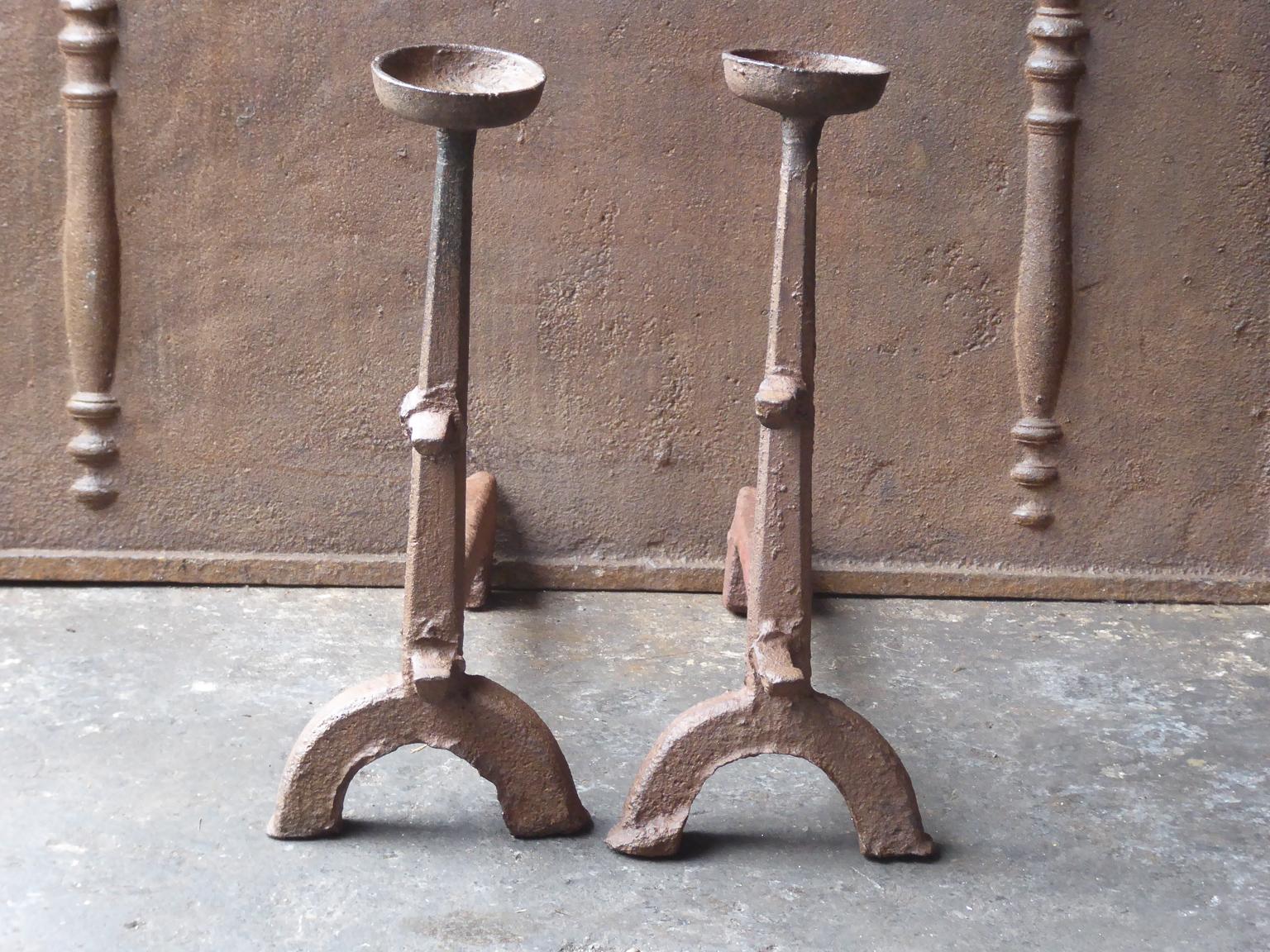 17th century French Gothic Andirons made of cast iron. The andirons have spit hooks to grill food and cups to keep drinks warm. This type of andirons is also called cup dogs. The patina of the andirons is brown. Upon request it can be made