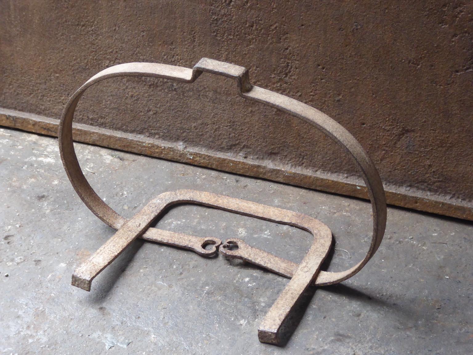17th century French hanging trivet made of wrought iron. The hanging trivet was used for cooking in the fireplace, to put a pot into. It was used in combination with a trammel and/or a chain. It is still fully functional.







      