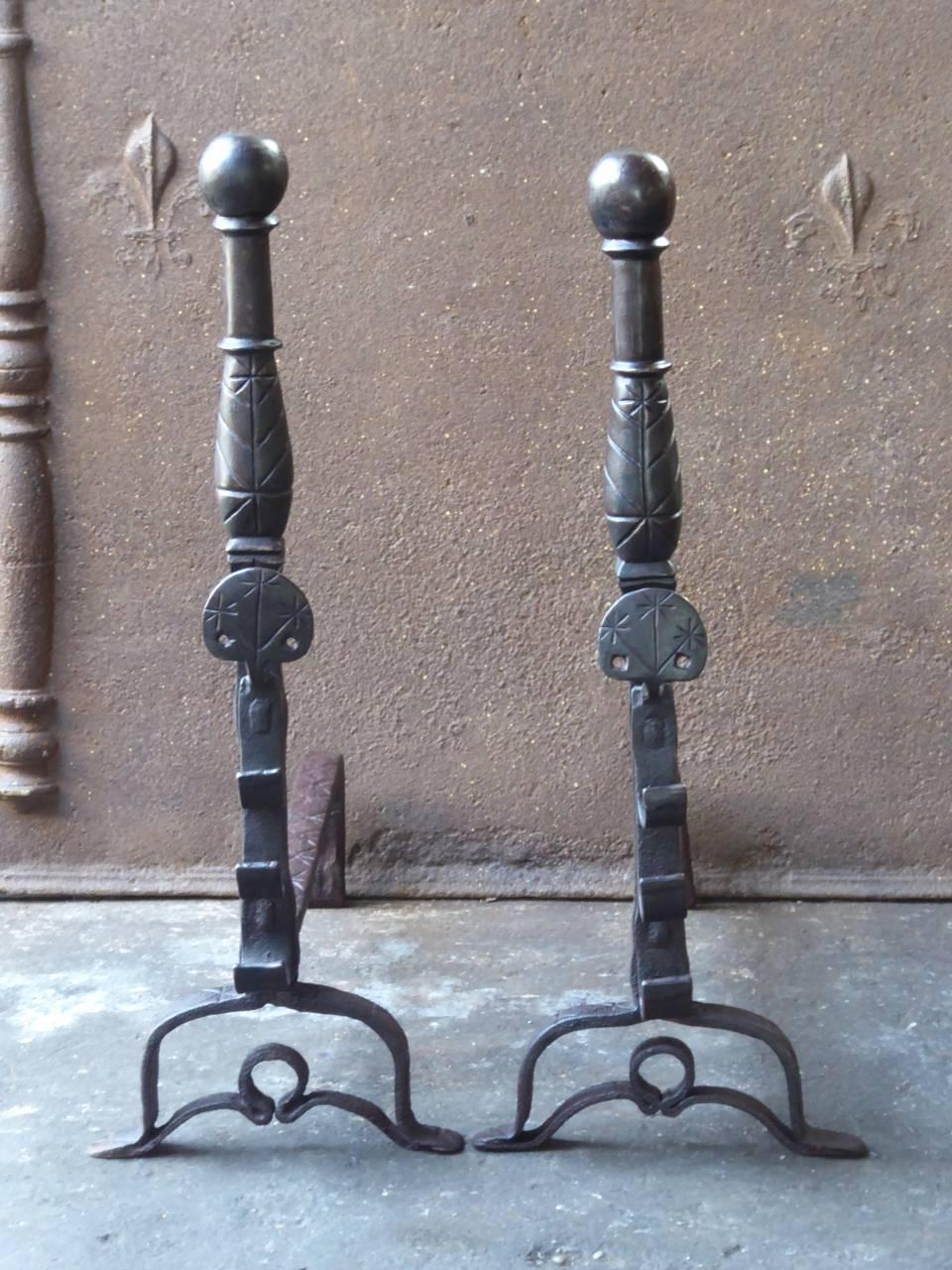 17th century French Louis XIII andirons or landiers made of wrought iron. This is a so called wedding pair, whereby both parties each donate one andiron made by the same blacksmith. With spit hooks.

We have a unique and specialized collection of