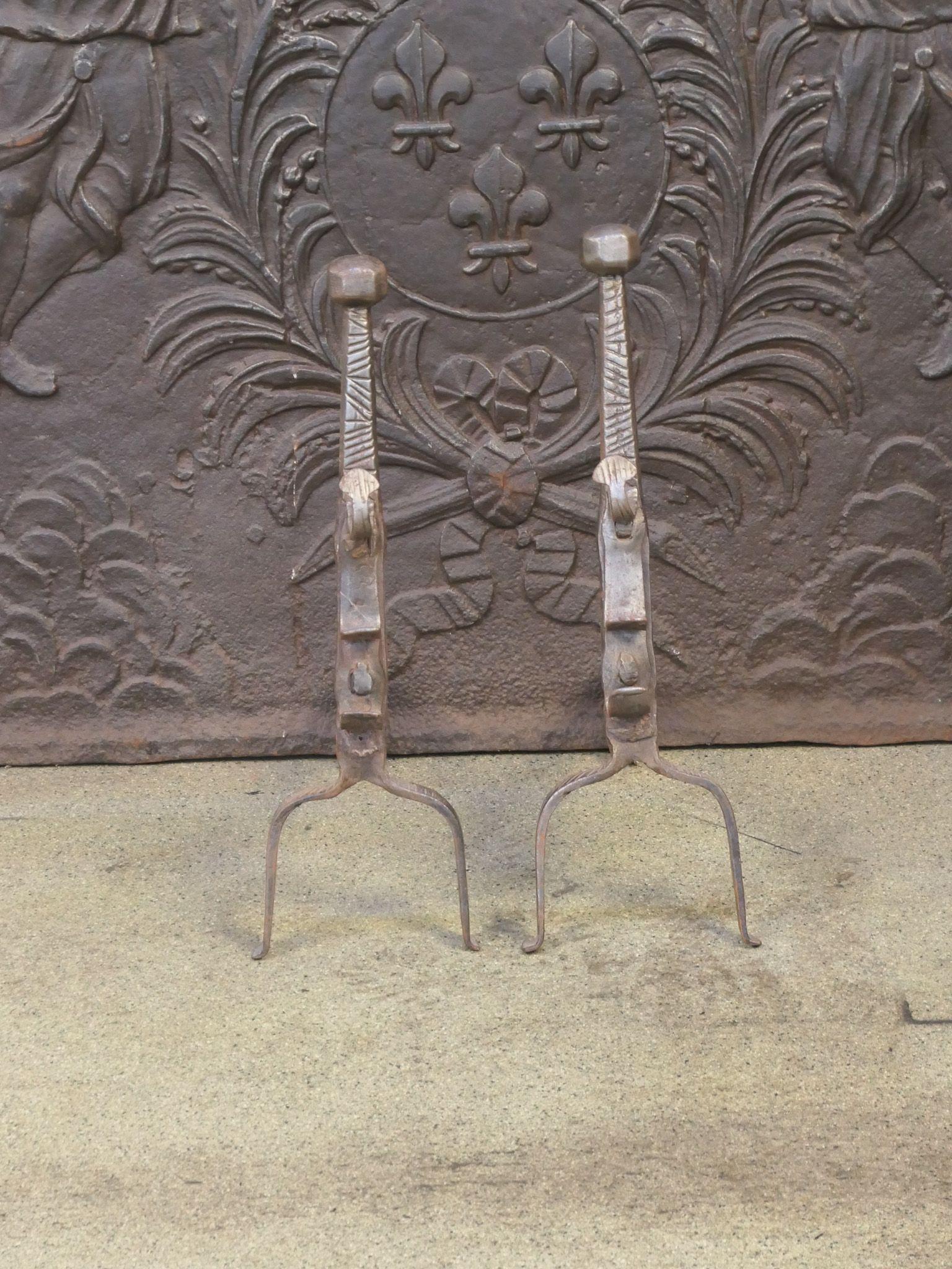 Beautiful 17th century French andirons made of wrought iron. The style of the andirons is Louis XIII Period.  The andirons have spit hooks to grill food. They are in a good condition, despite their age.