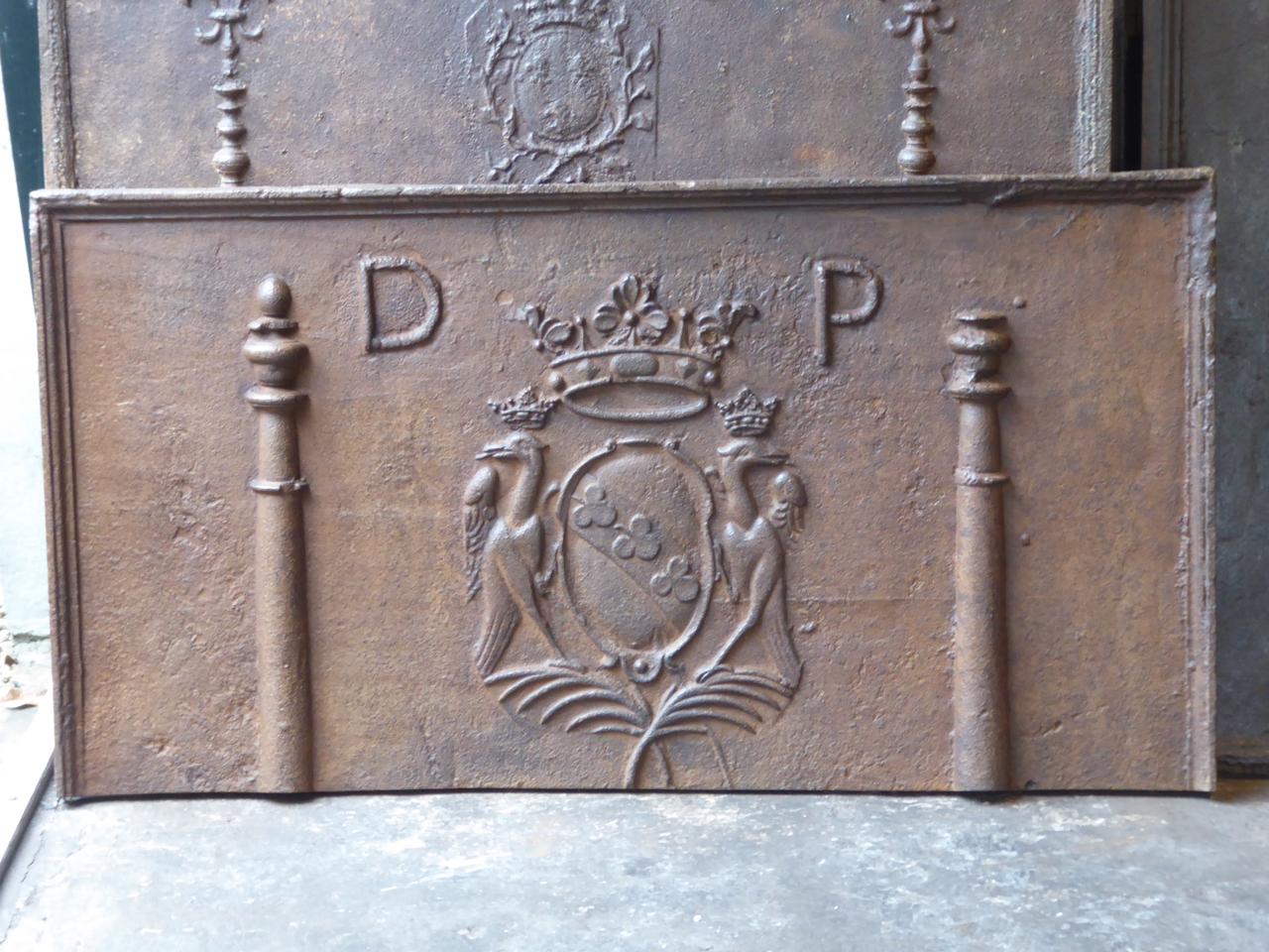 17th century French fireback with two pillars of Hercules, a coat of arms and the monogram D.P. The pillars stand for the club of Hercules and symbolize strength. The style of the fireback is Louis XIV and the fireback is of the Louis XIV