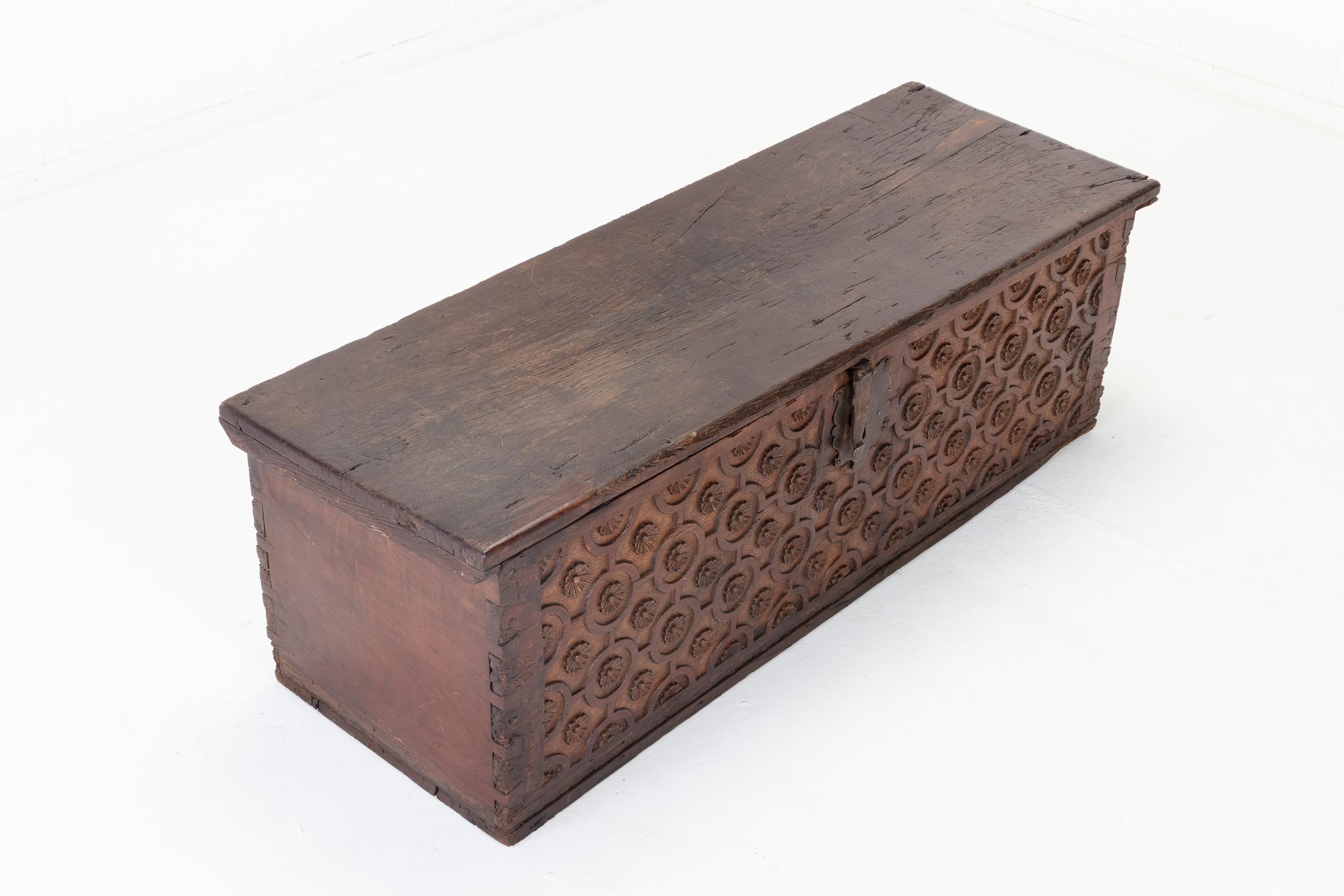 Superb 17th century French chest decorated with patterns of rosettes within circle carvings on the front panel. A solid construction having a single plank, hinged lid that opens to reveal two compartments. Four solid oak slabs with rustic