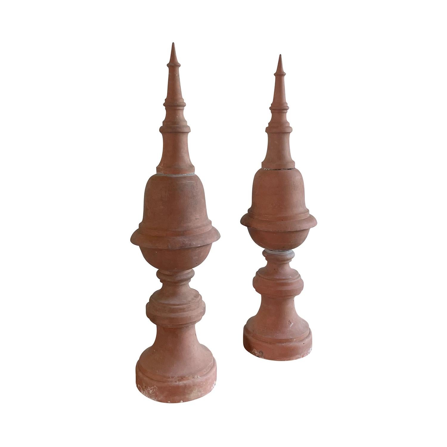 An antique pair of 17th Century French garden ornaments made of hand crafted terra cotta clay. These finials have turned pointed finial tops and are raised onto a circular base with a stamp of 