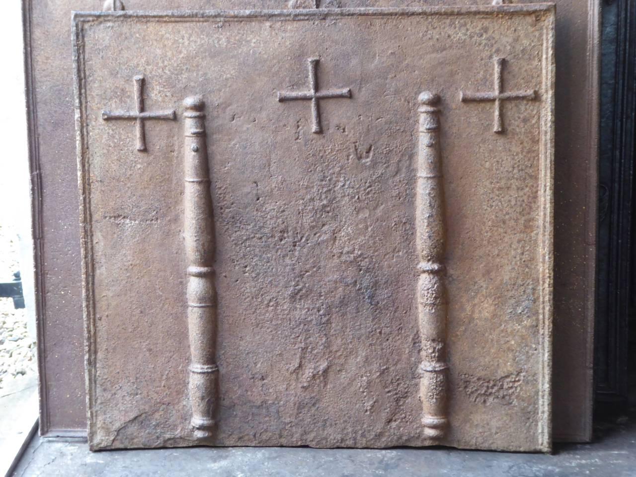 Caminetto francese del XVII secolo con due colonne d'Ercole e tre croci. La colonna d'Ercole rappresenta la forza e l'ignoto.

Lo schienale del camino presenta una patina marrone naturale. Su richiesta può essere realizzato in nero/ peltro. Le