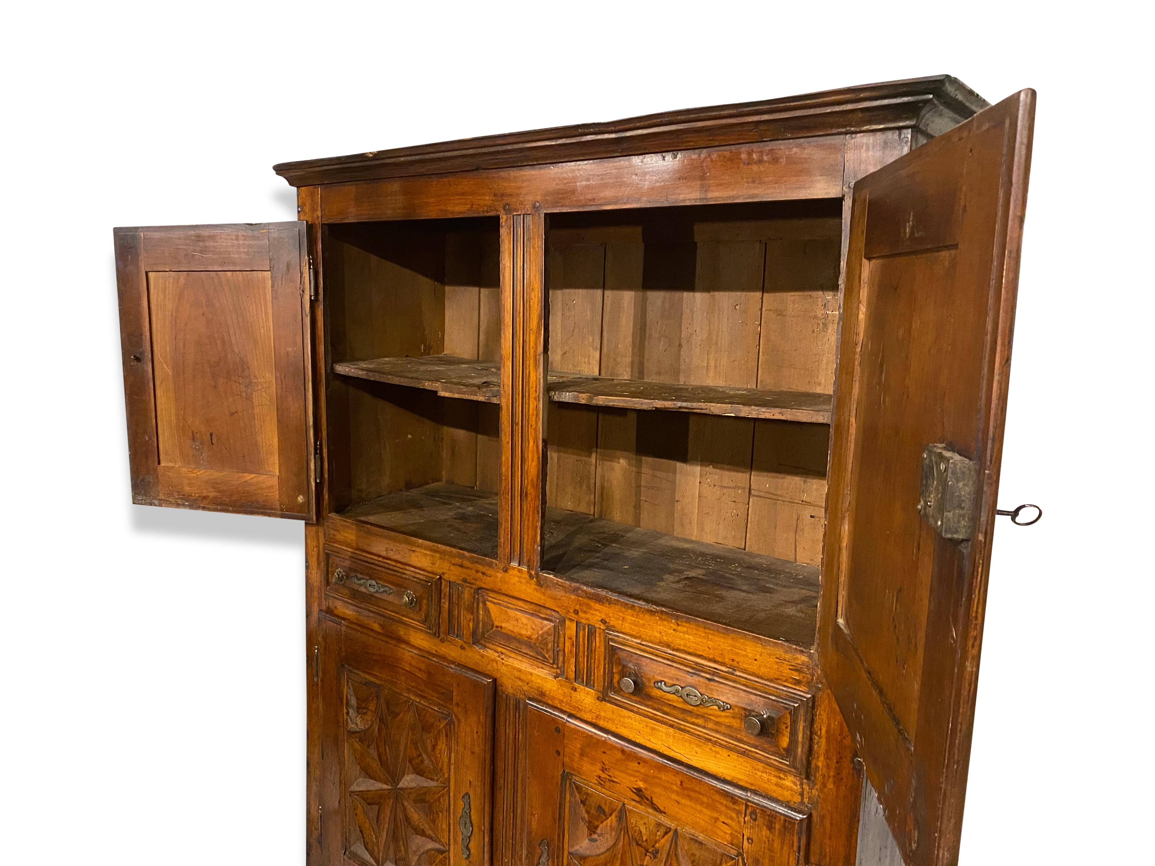 A Stunning French Walnut Provincial cupboard dating from the early 17th Century in the period of Louis XIII.Consists of four carved panelled doors with two drawers and the original ironmongery making this into a truly wonderful and usable early