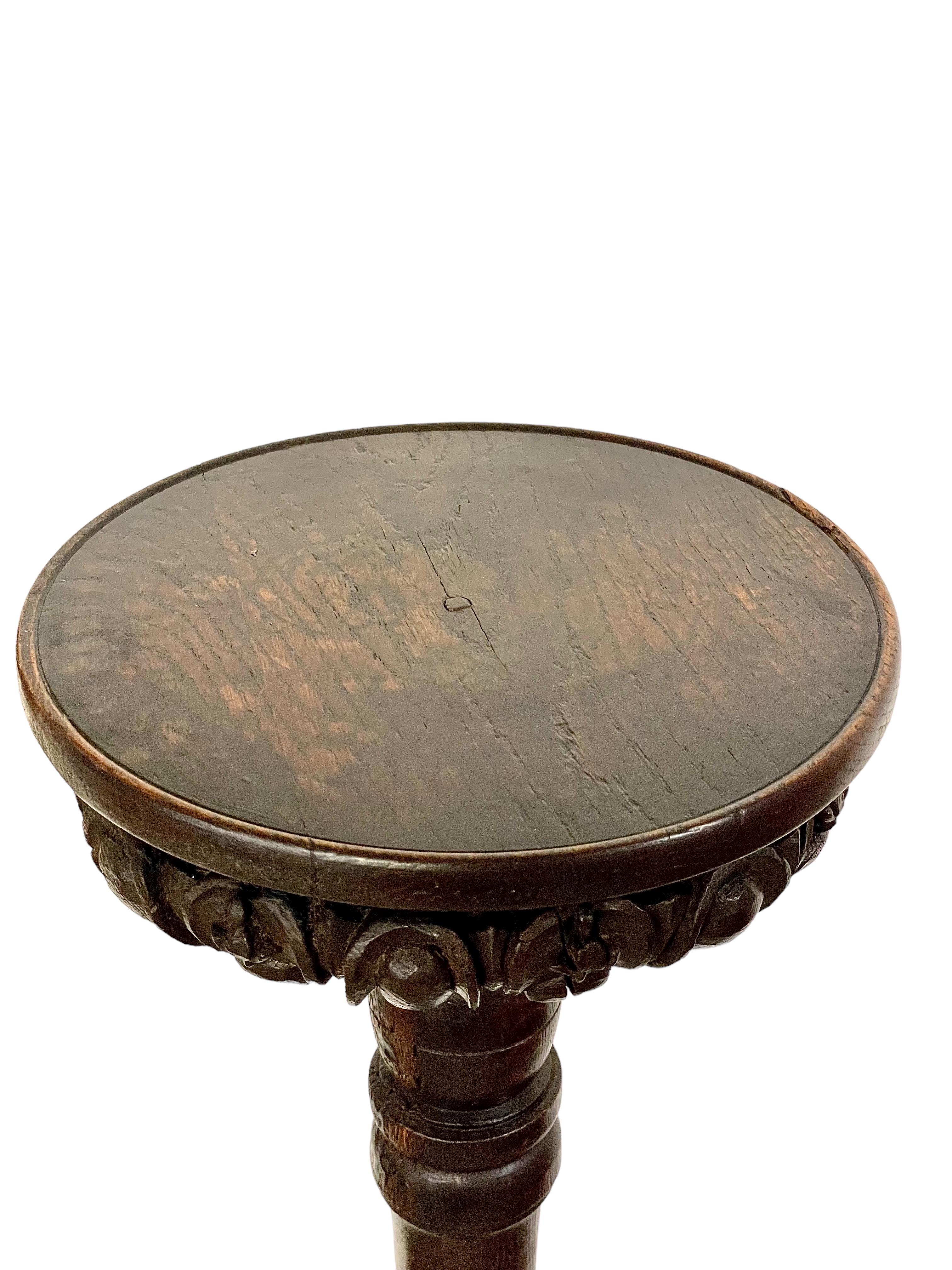 A fine quality 17th century torchère, or pedestal, with an elegantly turned column and deeply tiered circular base. The top surface is a flat polished disc with a finely carved and gadrooned underside. In excellent original condition with a rich