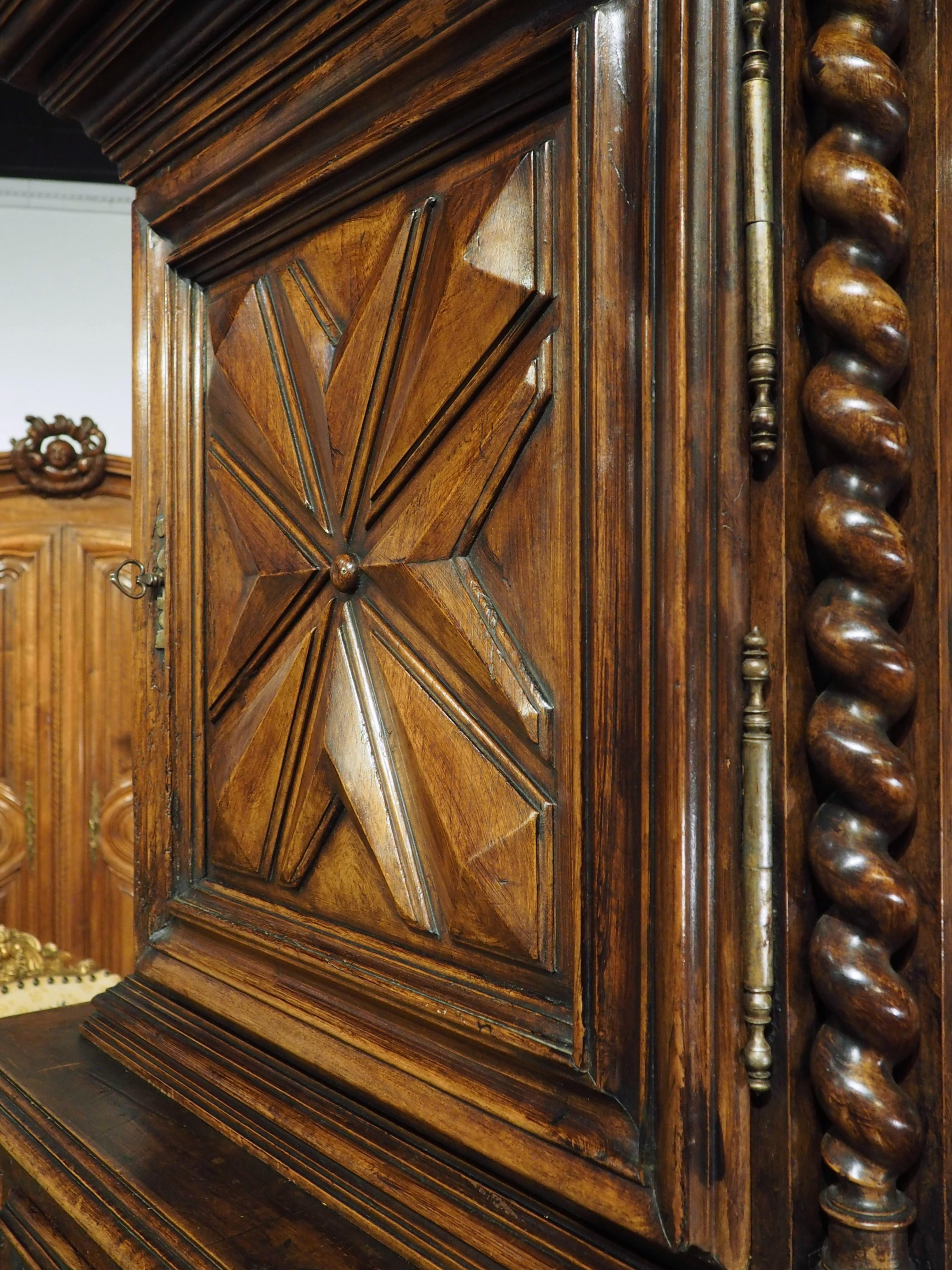 This unique buffet deux corps was hand-carved from walnut wood in France during the Louis XIII period (1600’s). A buffet deux corps (literally “two body buffet”) is a two-tiered cabinet where the upper section sits on top of a wider lower