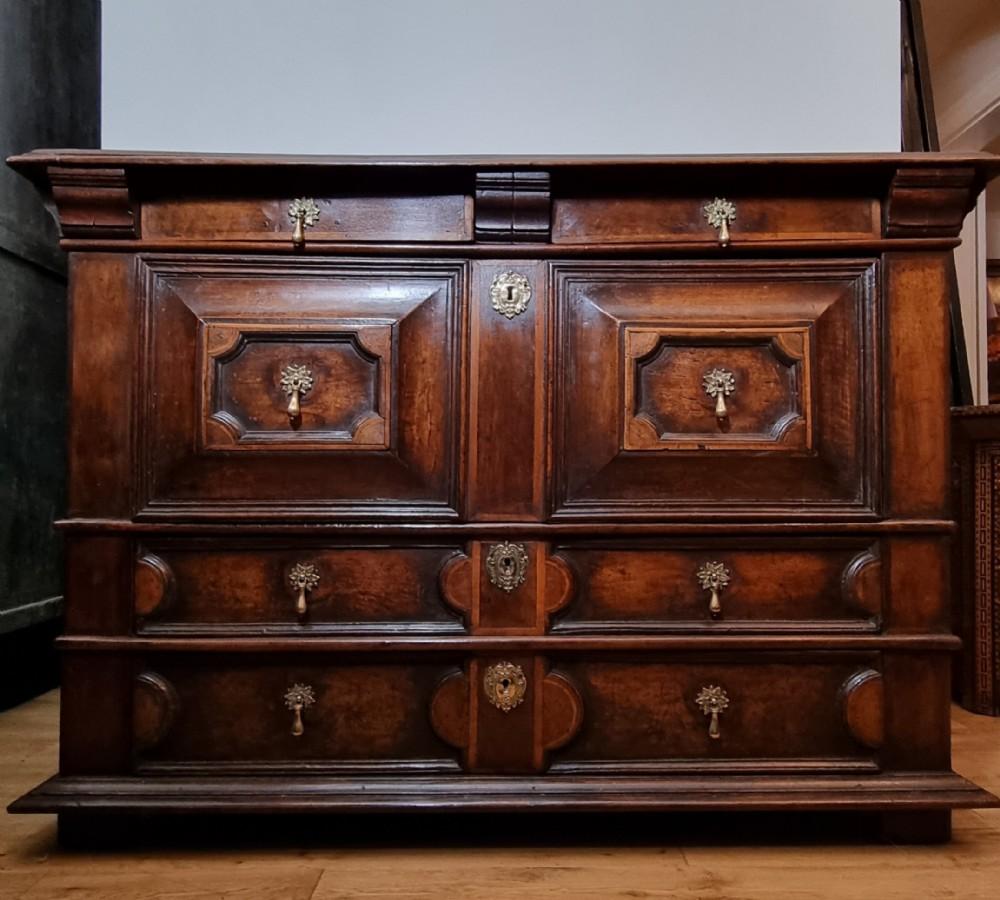 Eine äußerst seltene geometrische Kommode aus Nussbaum mit Intarsien aus dem 17. Jahrhundert, datiert auf 1660, mit zwei kurzen Schubladen, einer großen zentralen Kissenschublade, zwei unteren langen Schubladen und einer geheimen Schublade. Diese