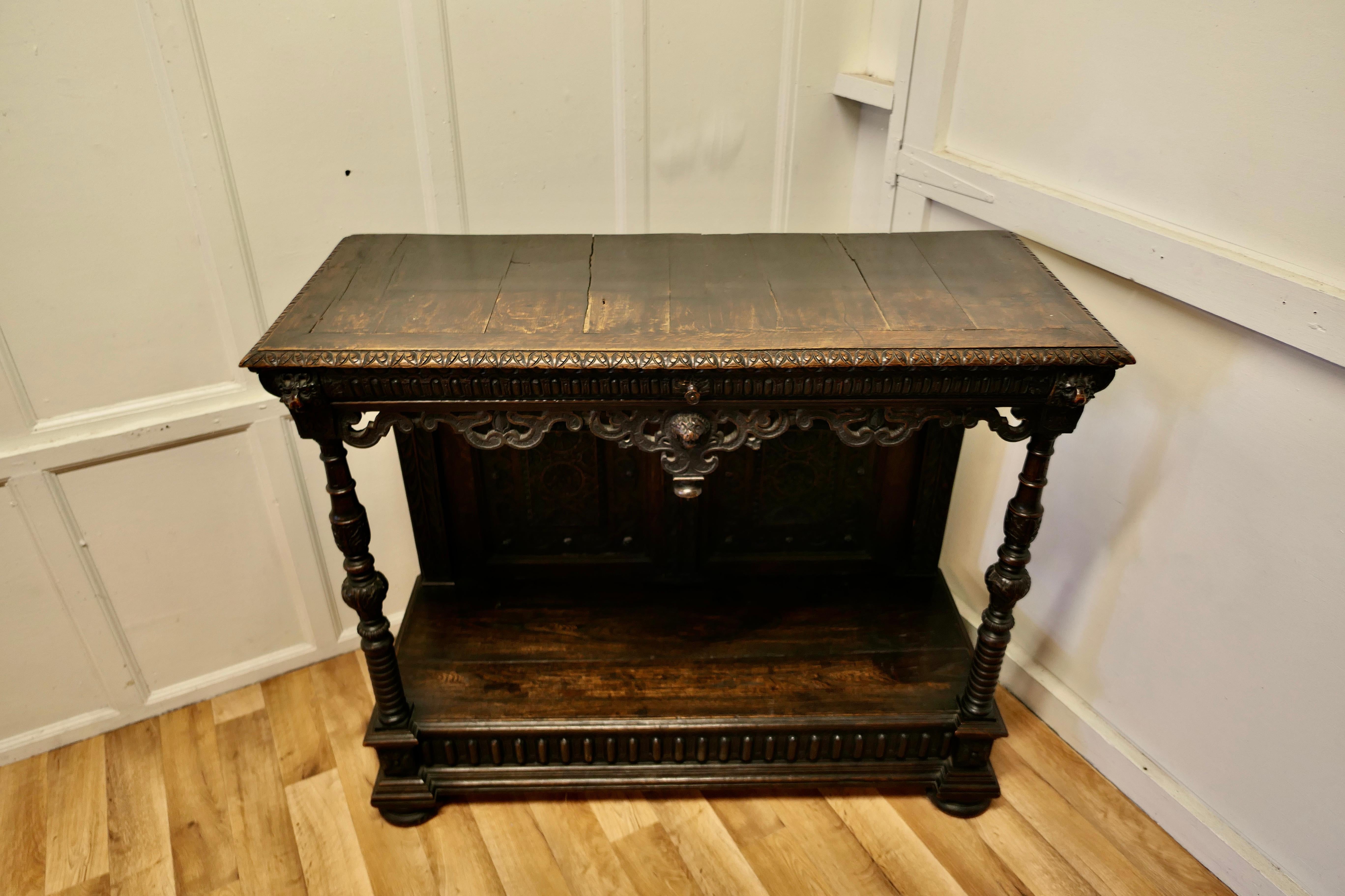 17th century gothic carved oak green man buffet, serving table 

This is an elegant example of furniture carved in the Gothic style of Green Man Oak, which has an elaborate decorative carved apron with 3 unusual faces carved on the front
The