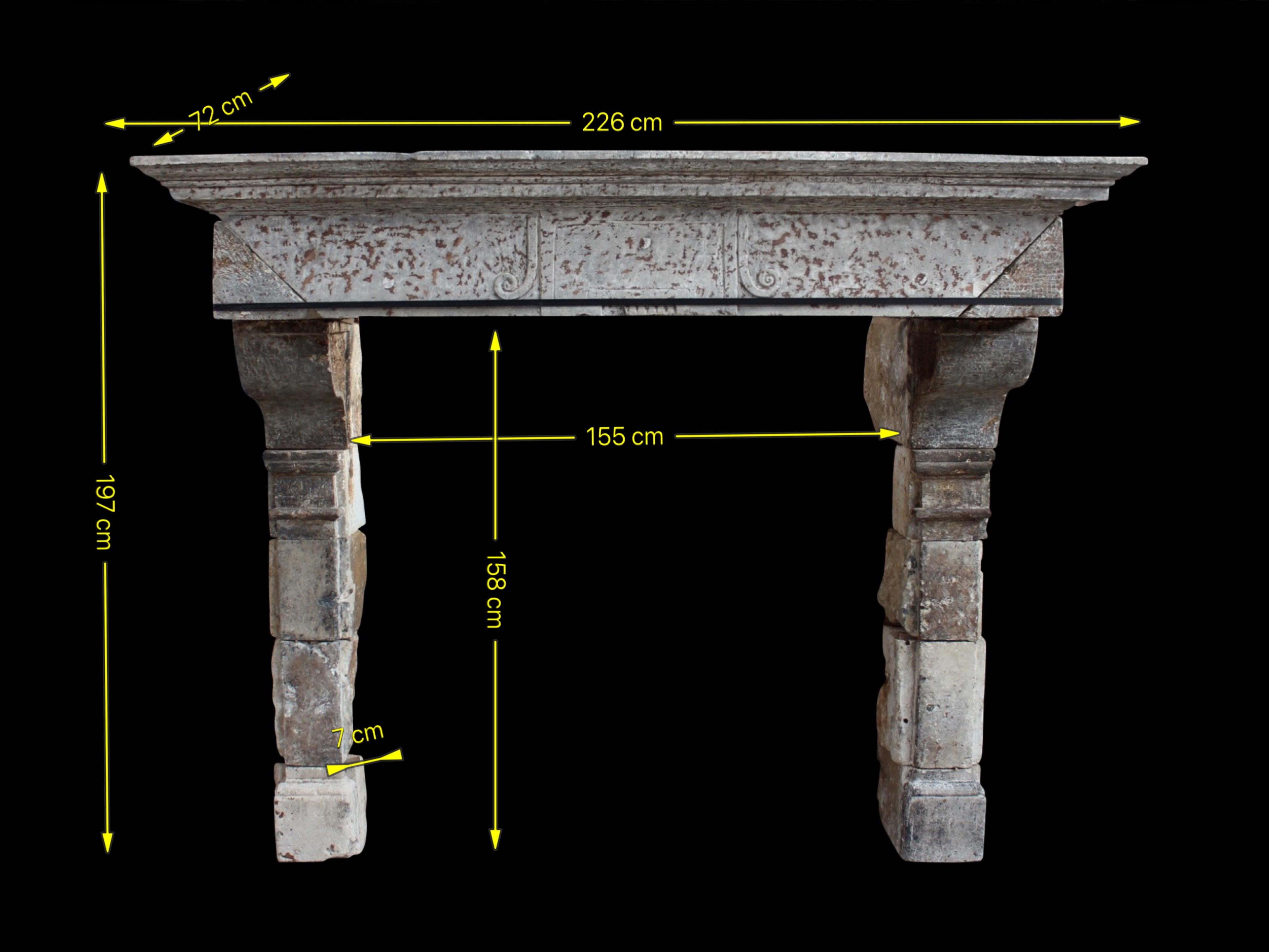 Un grande camino antico di campagna francese. Questo incredibile caminetto in pietra calcarea ha una grande patina originale. I bellissimi dettagli con le cornici per proteggere la facciata dai danni dell'acqua in caso di perdite del tetto derivano